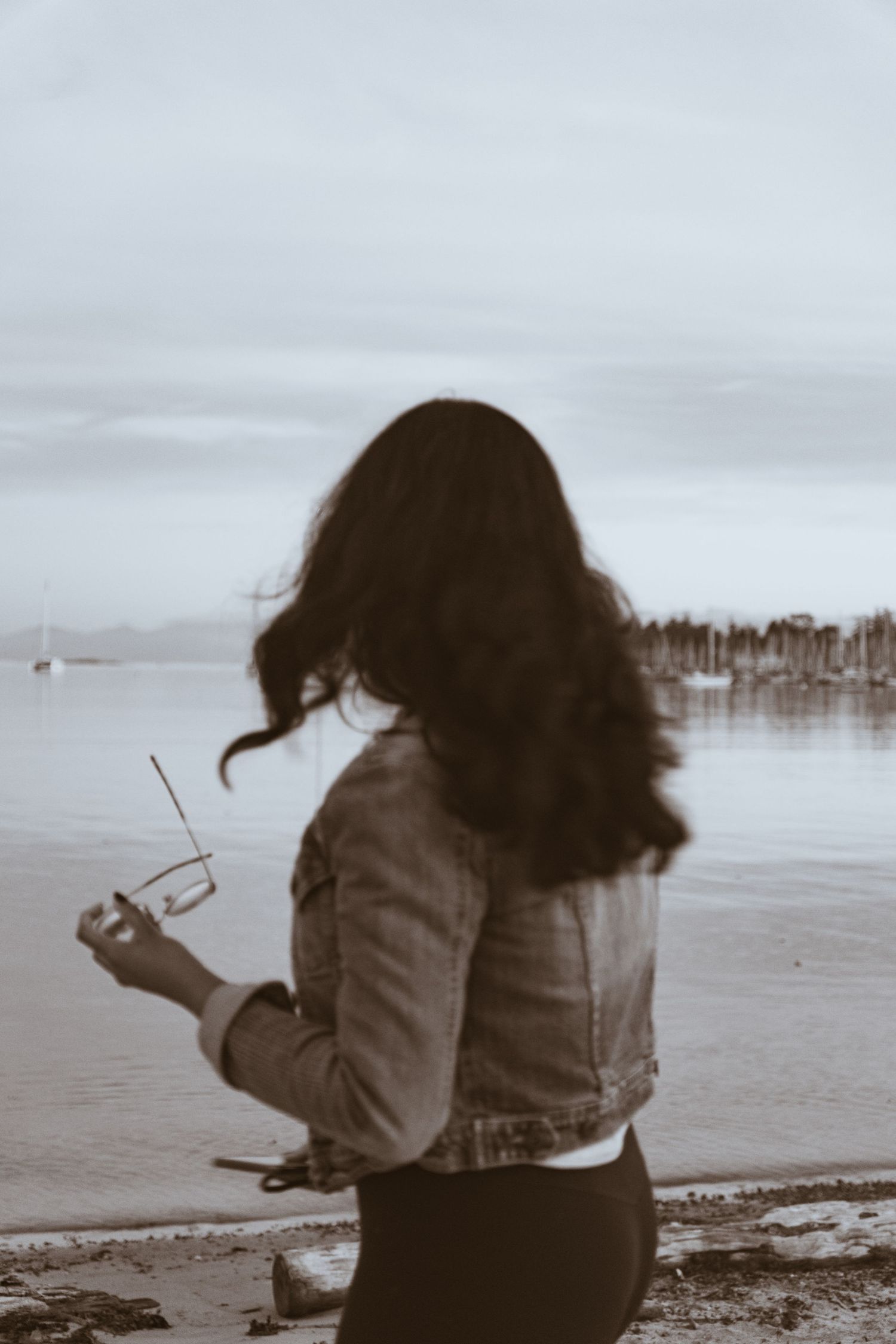 Black and white filter evening close-up of a women looking at the beach during sunset shoot in Cadboro-Gyro park in Victoria