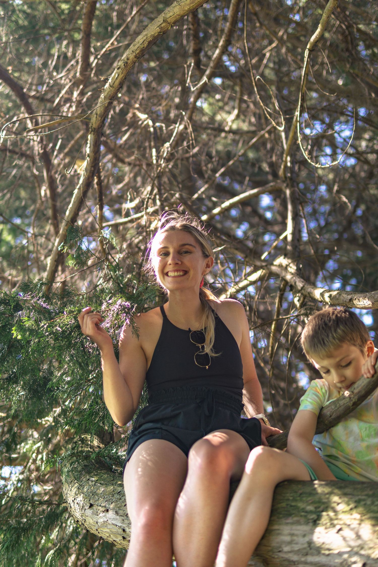 Candid shot of a women smiling on the tree trunk in a park in Victoria