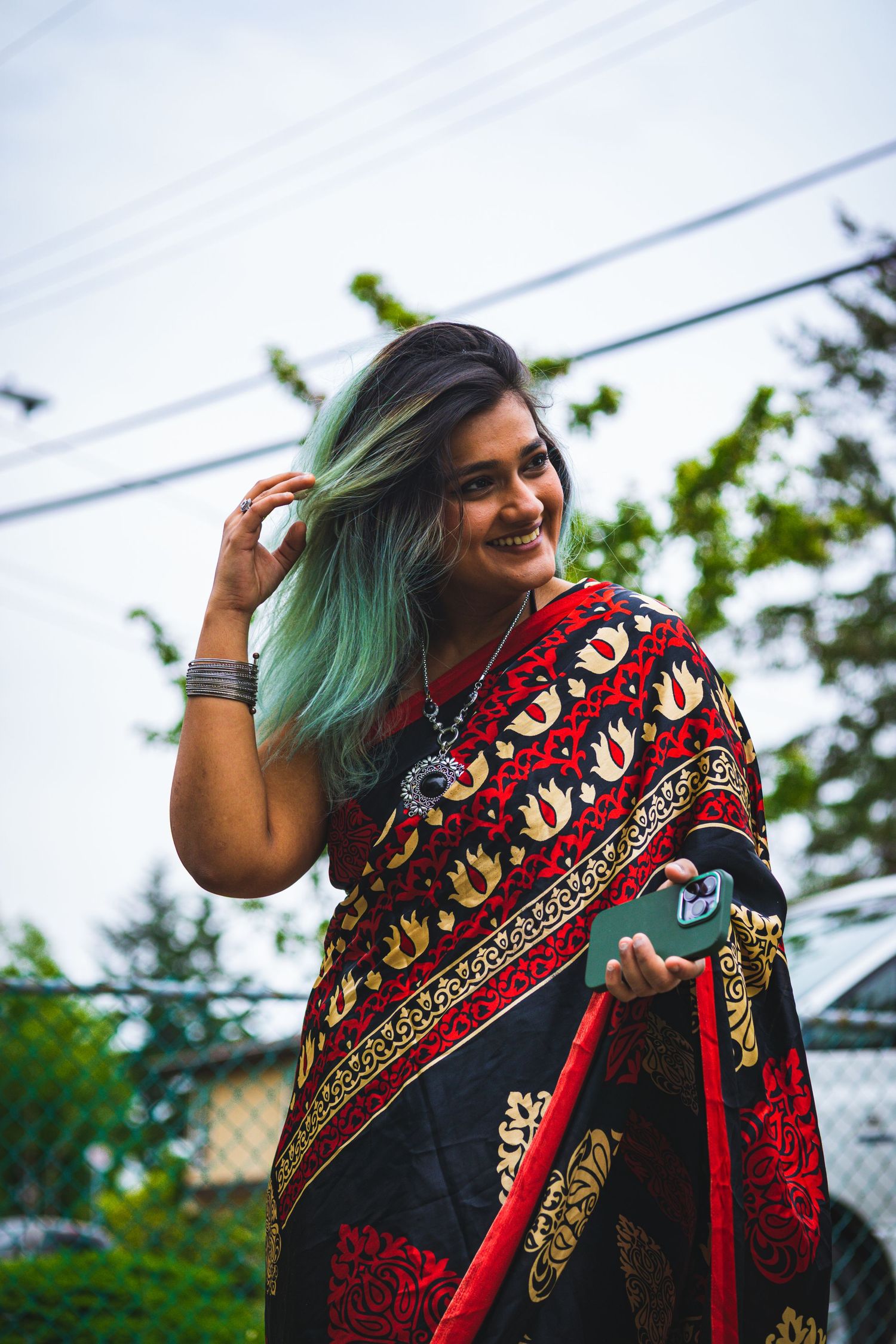 Candid shot of woman in red saree, laughing mid-movement in natural light in Victoria, Canada