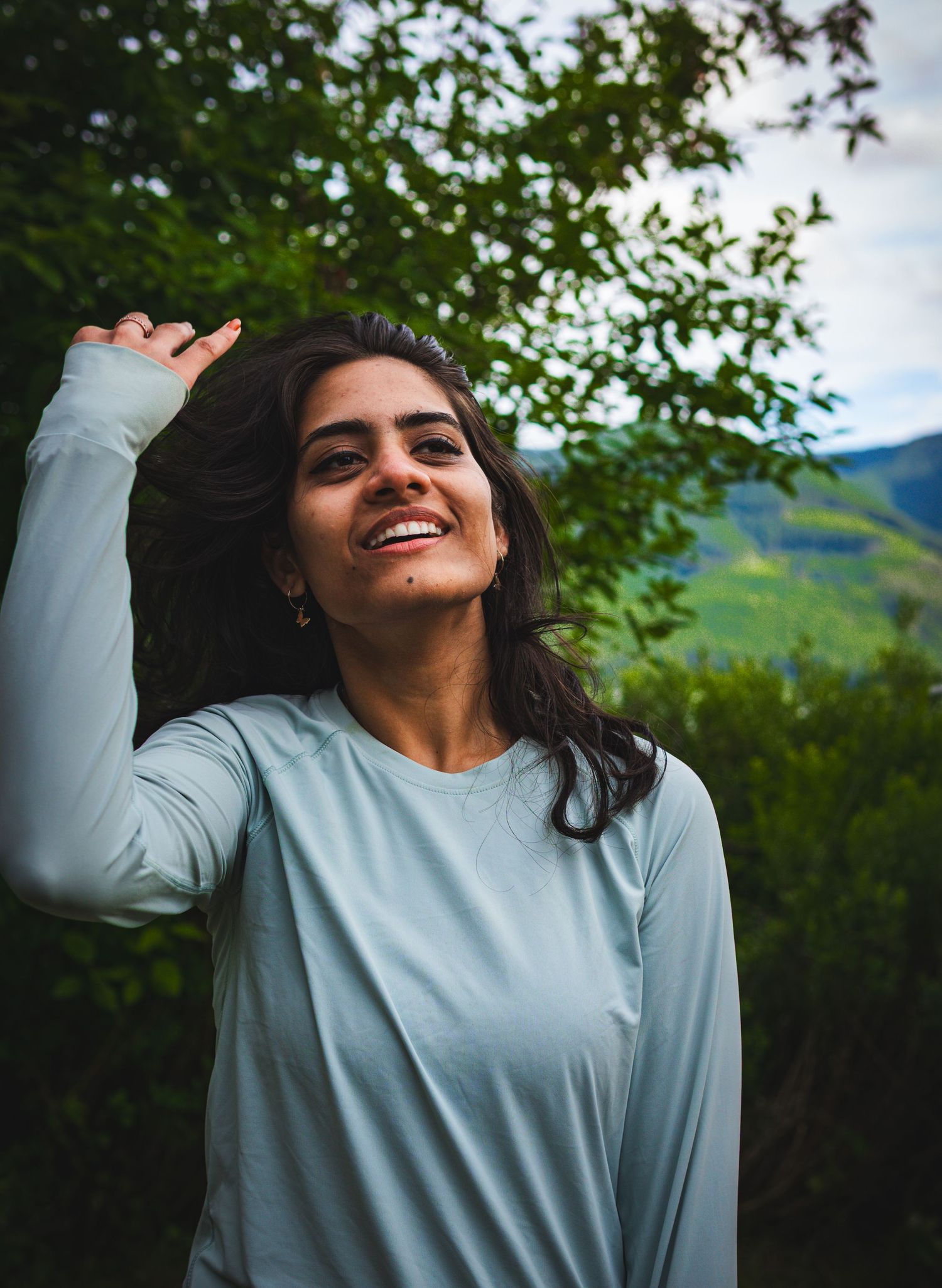 woman candidly laughing on a hike on a sunny afternoon in Buntzen lake, Vancouver