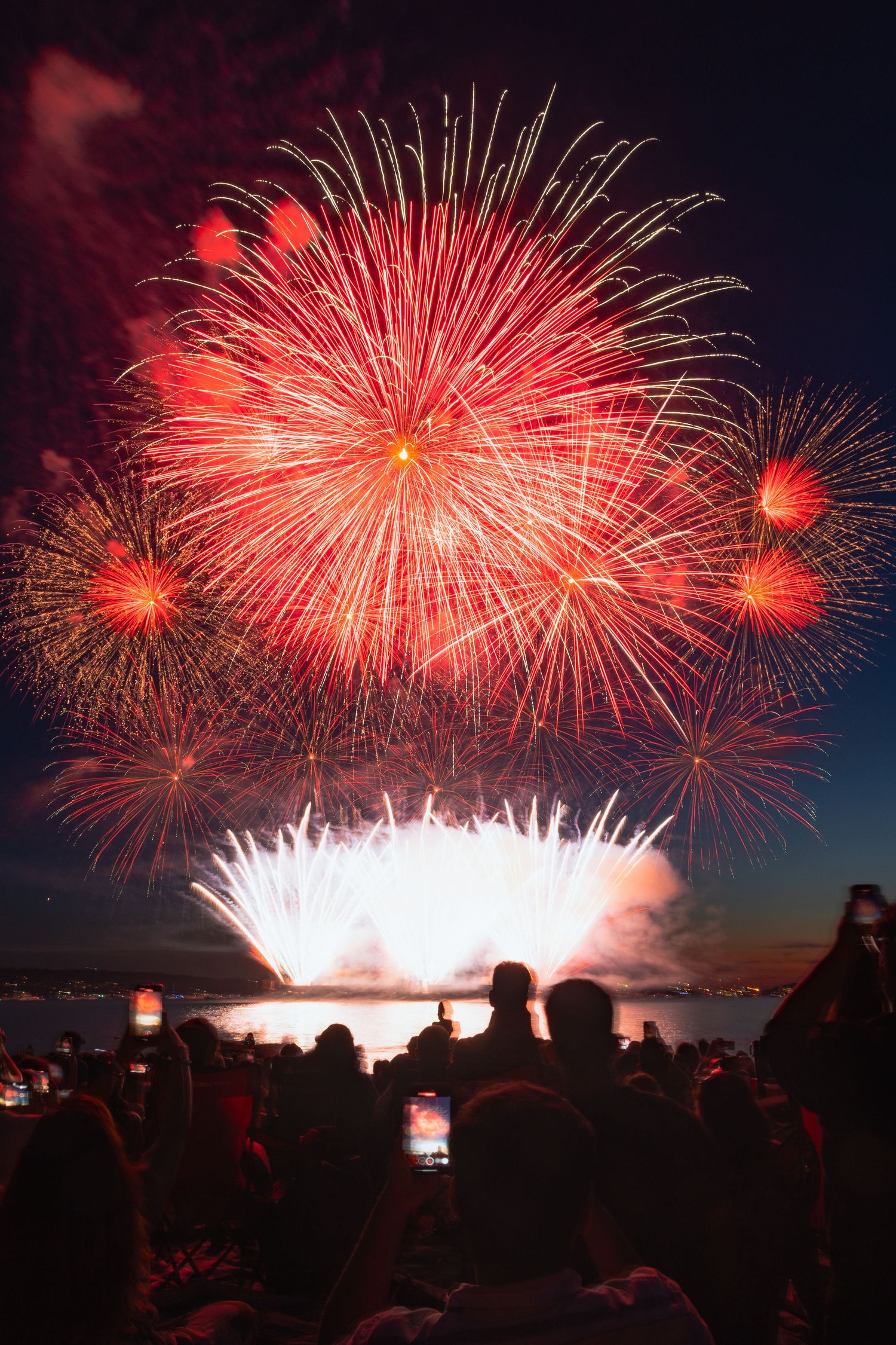 Bright streaks of red and silver fireworks crossing the sky