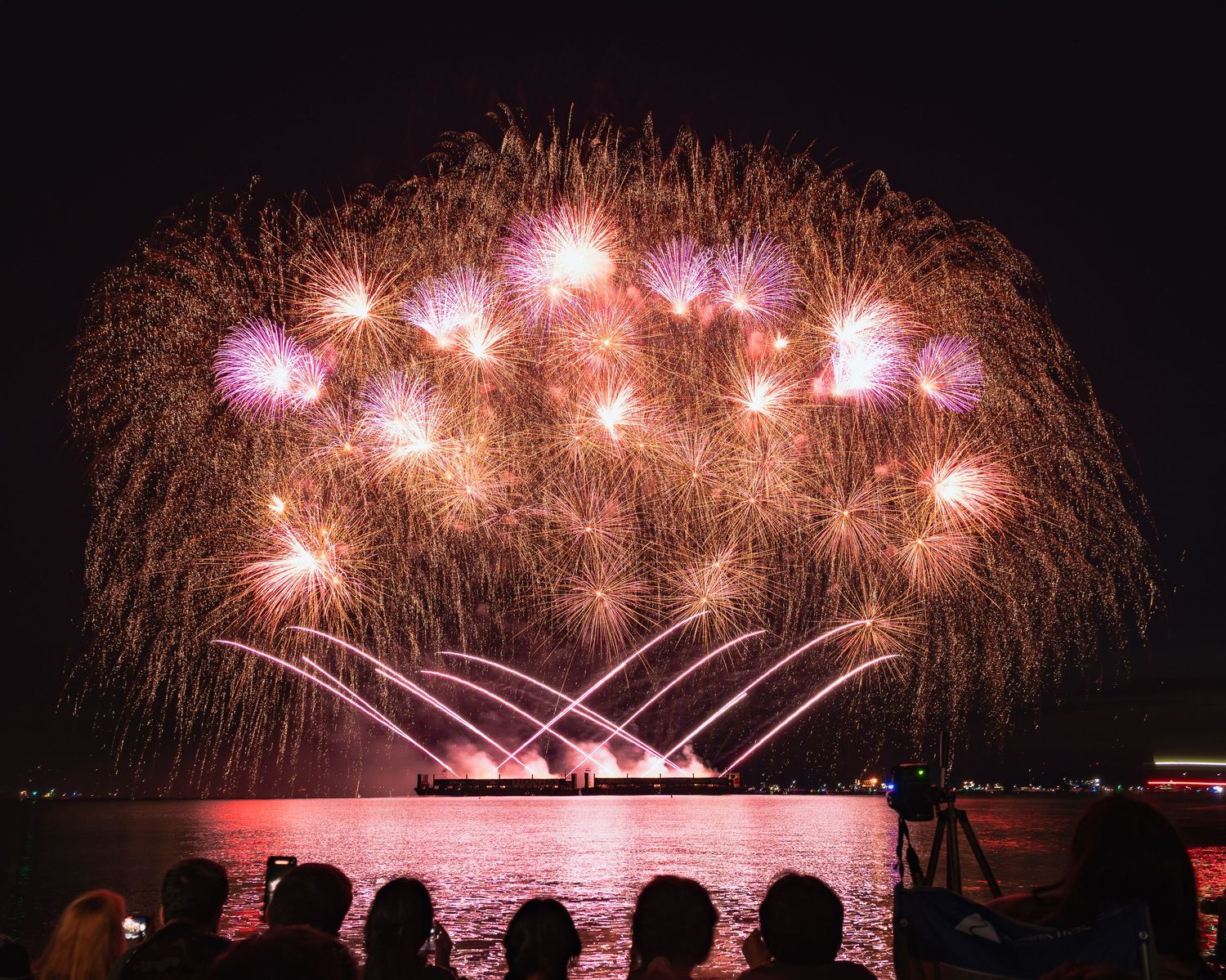 Dramatic fireworks lighting the Vancouver skyline with vibrant pink/purple colors