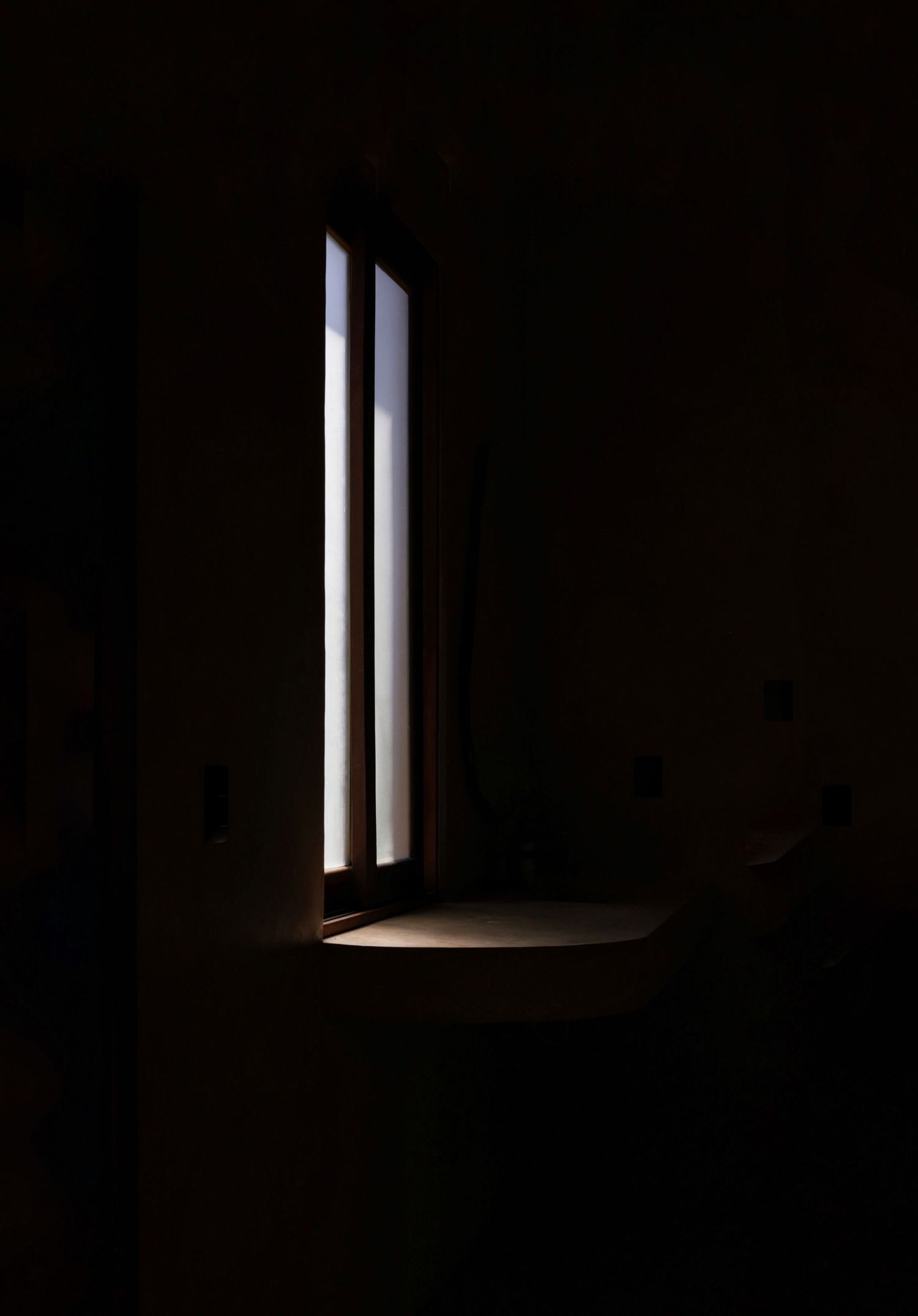 una foto en blanco y negro en la que solo se ve una luz que se refleja por la ventana