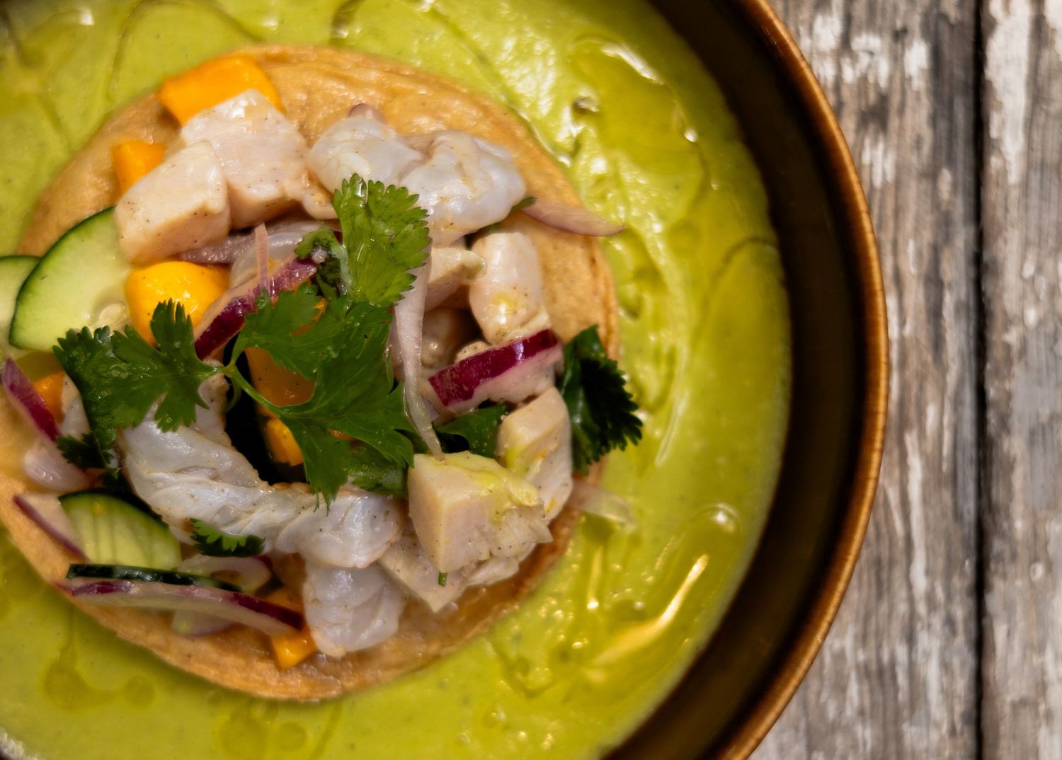 fotografia gastronomica cenital, detalle de un plato en el que se observan vertudas y una flor. aguachiles