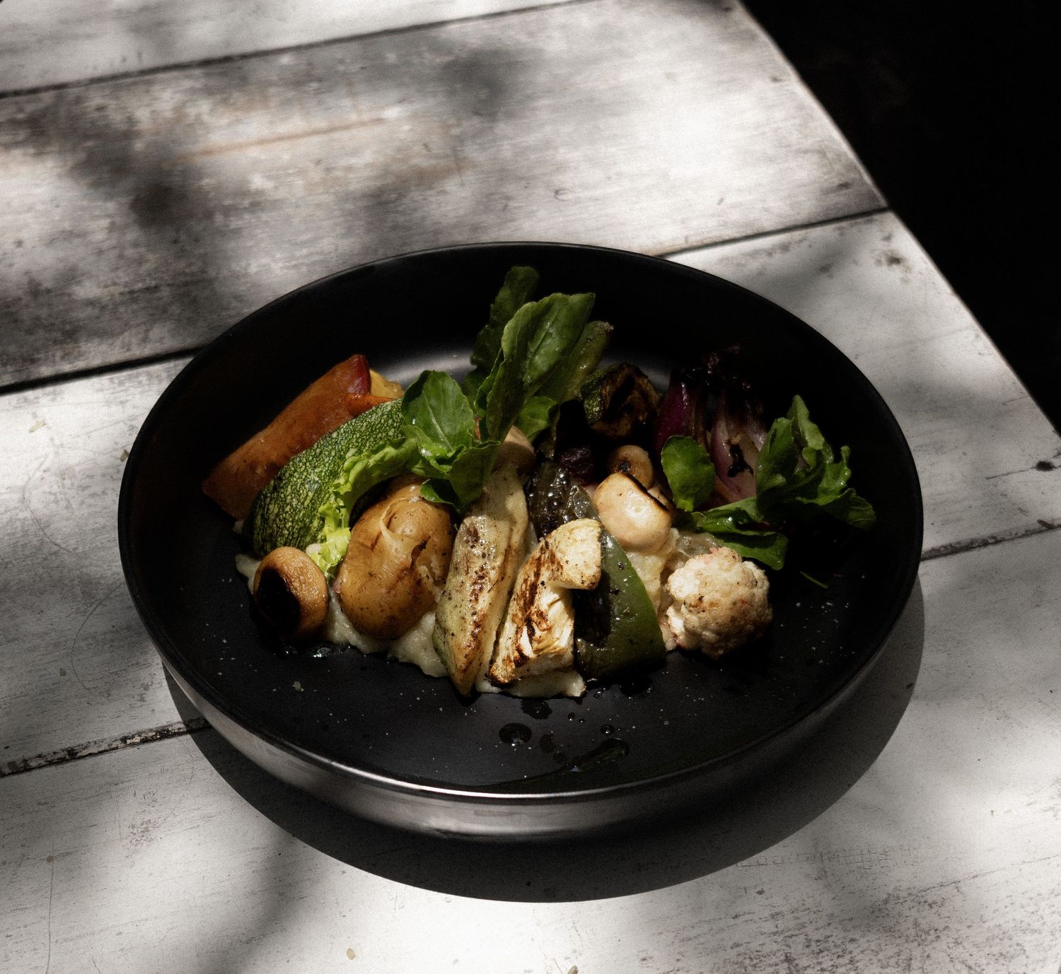 fotografia gastronomica, un plato de ensalada sobre una mesa con toma a 45 grados