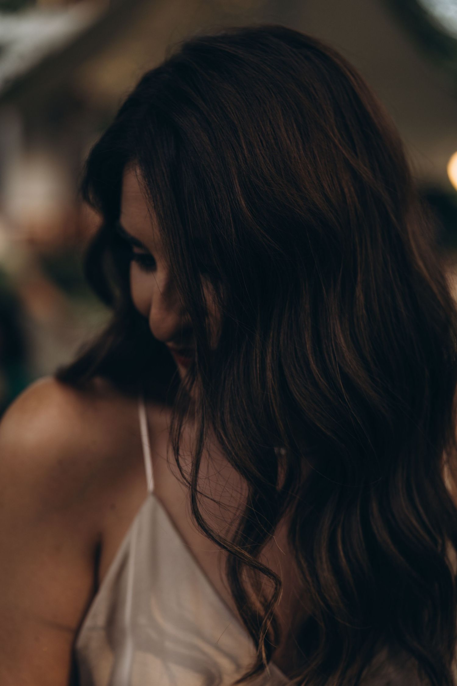 Artistic close-up shot of dark wavy hair against a blurred background.