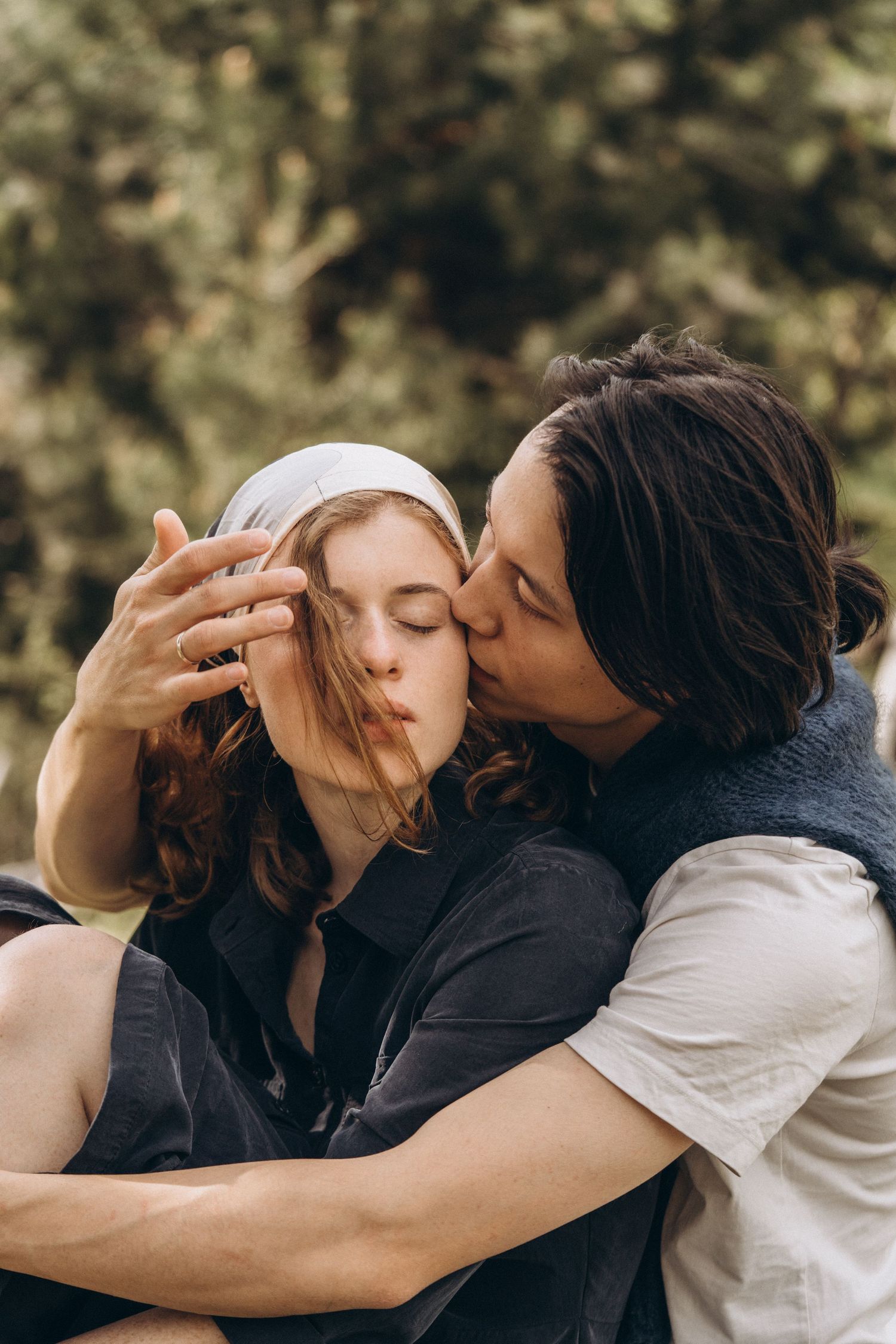 An intimate moment captured between two people embracing outdoors.