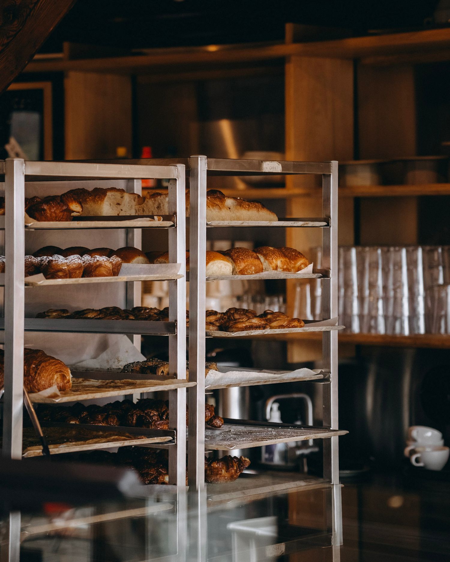 Industrial bakery shelving displays rows of freshly baked goods and glassware.