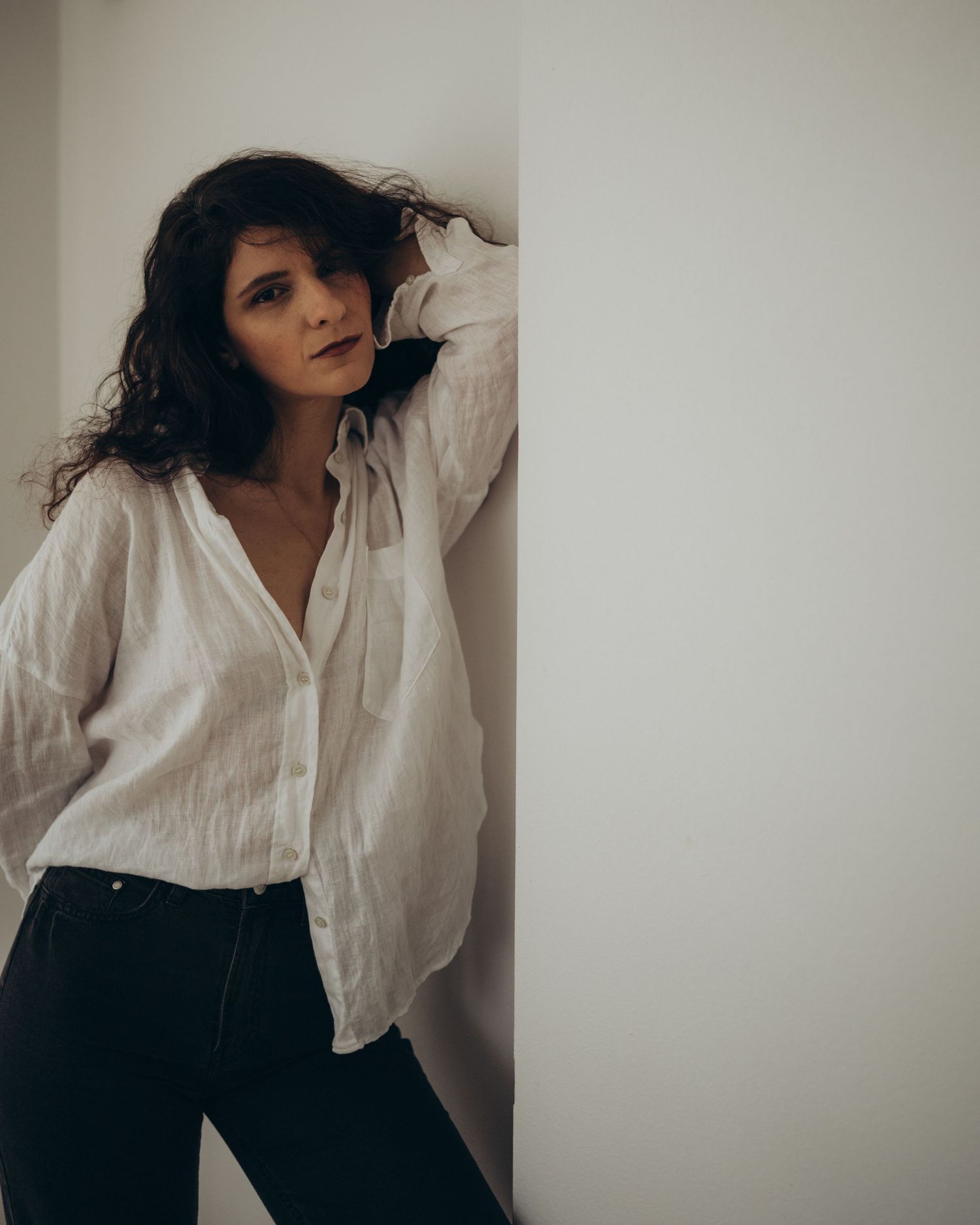 Fashion photography series featuring flowing white shirt and dark pants against neutral backdrop.