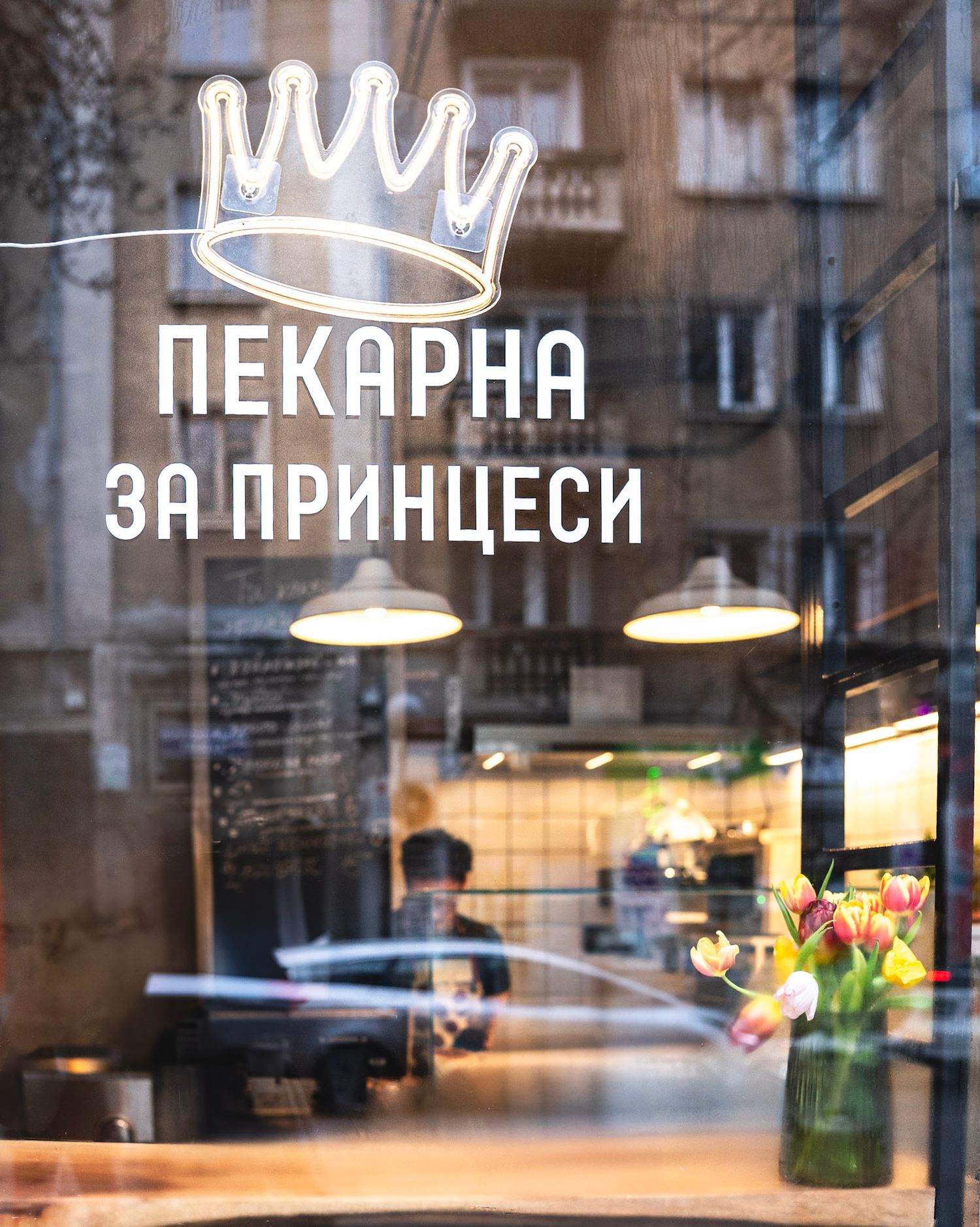 Store window with illuminated text signage in Cyrillic letters.