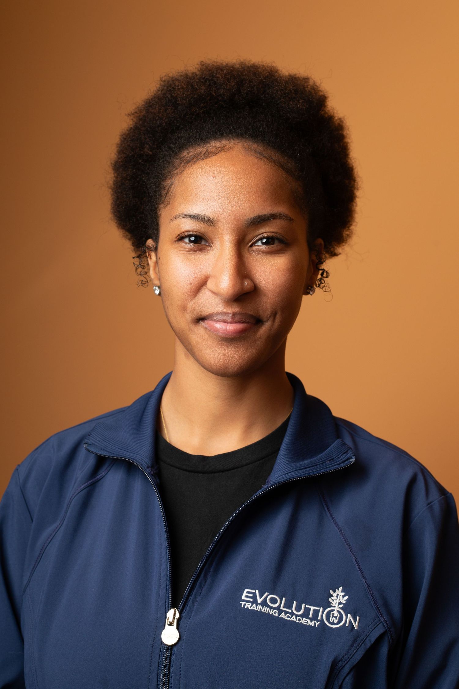 Professional headshot series showing expressions and poses against a warm brown background wearing a navy blue jacket.