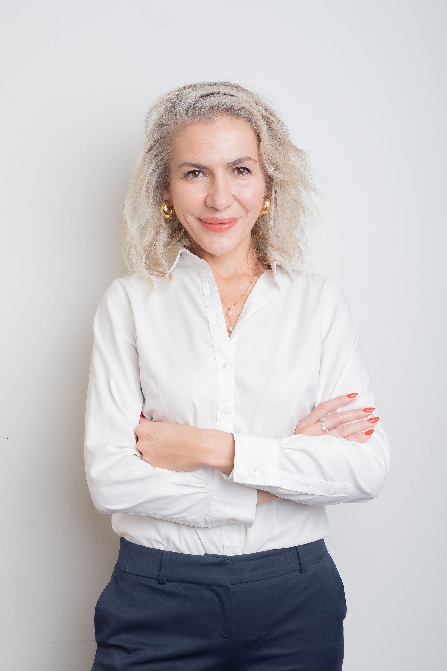 Professional business portrait series showing a person in a white blouse and navy pants against a light background.