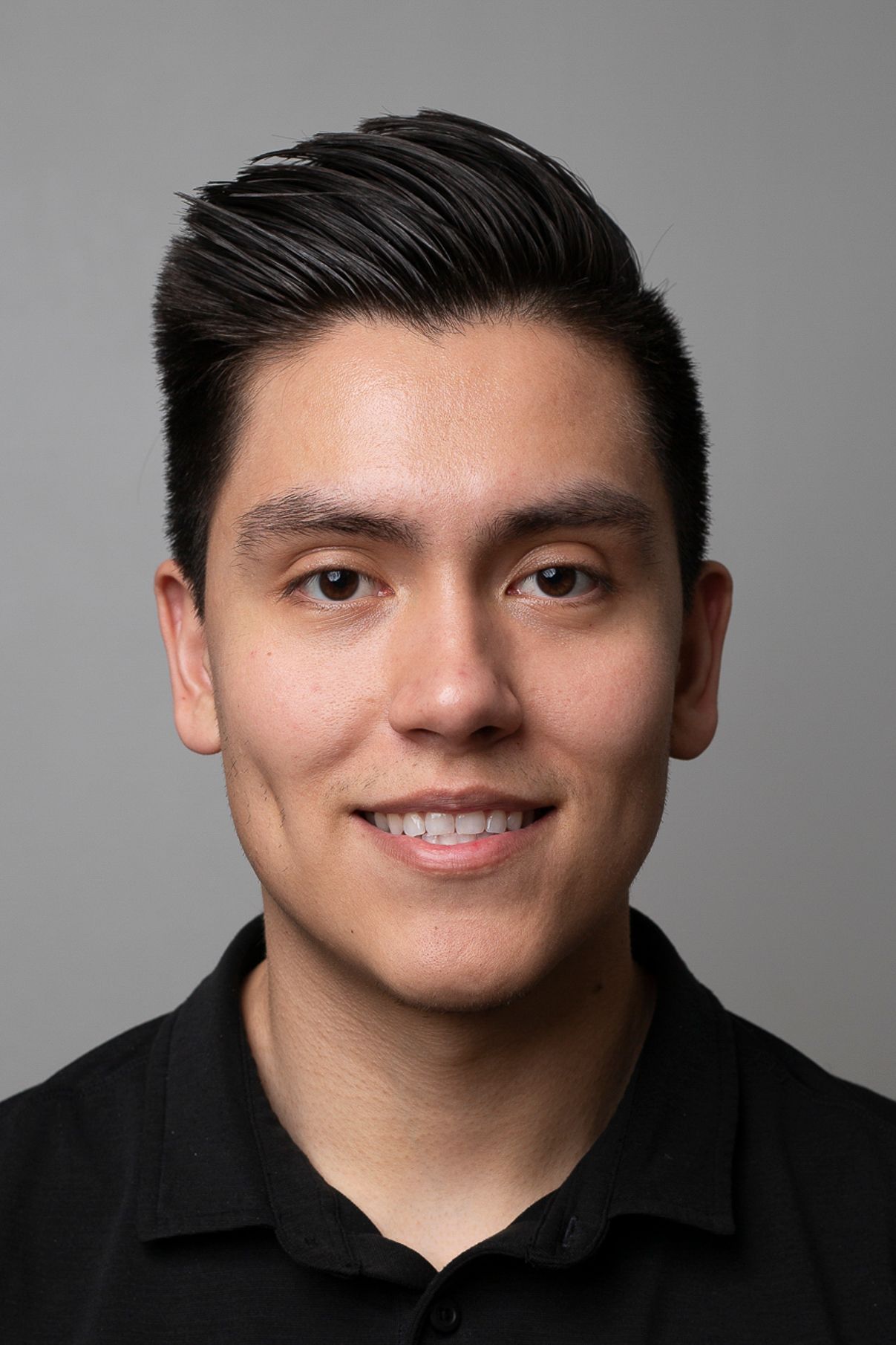 Professional headshots of person in black polo showing various expressions against gray background.