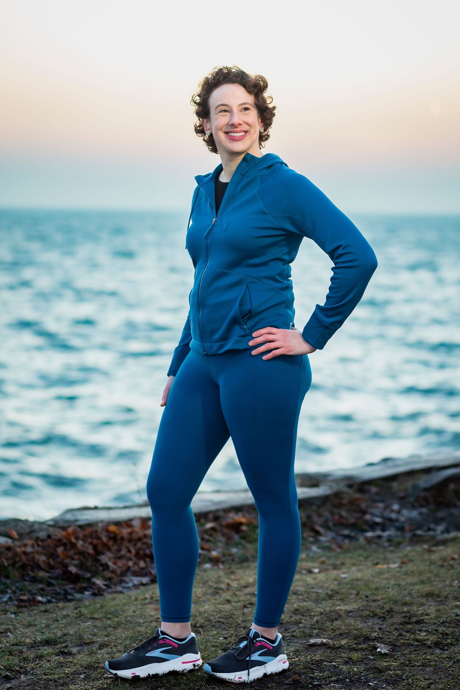 Outdoor portrait series by ocean at sunset wearing bright blue athletic wear.