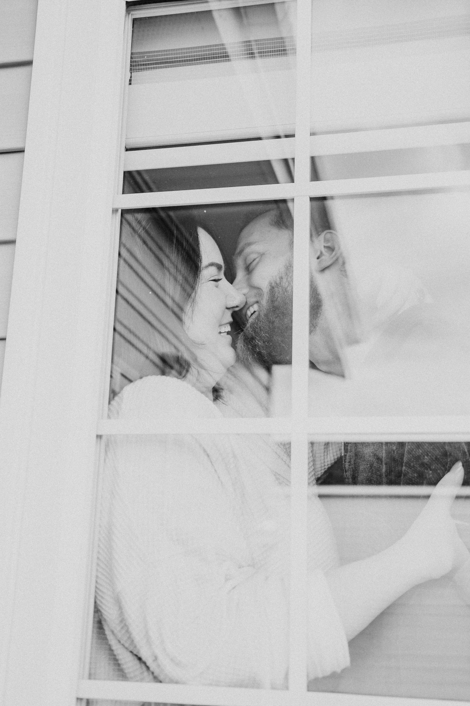 Through the window a couple snuggles in for a sweet, romantic moment