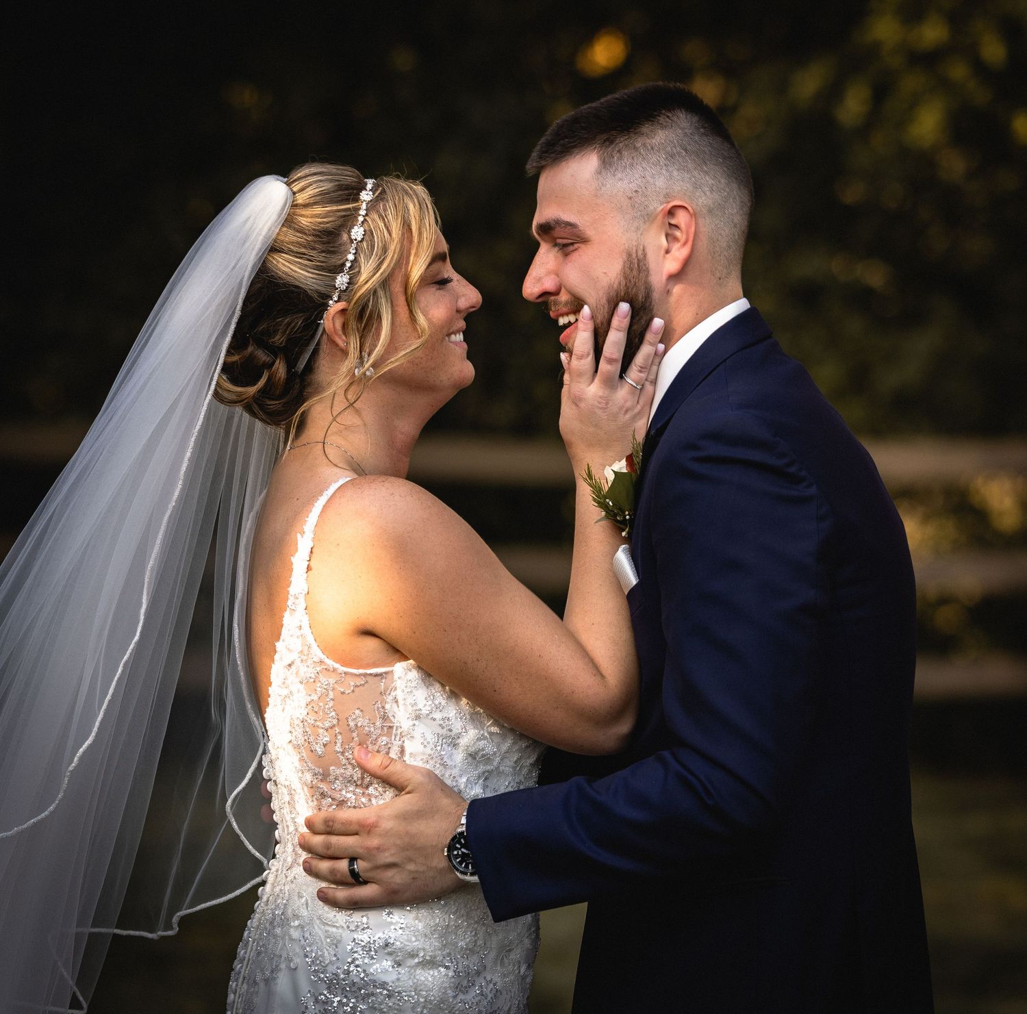 Smiling bride and groom sharing joyful moment outdoors at golden hour wedding portrait.