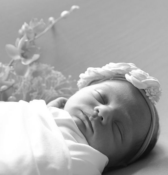 Black and white profile shots of a peaceful sleeping newborn baby in soft lighting.