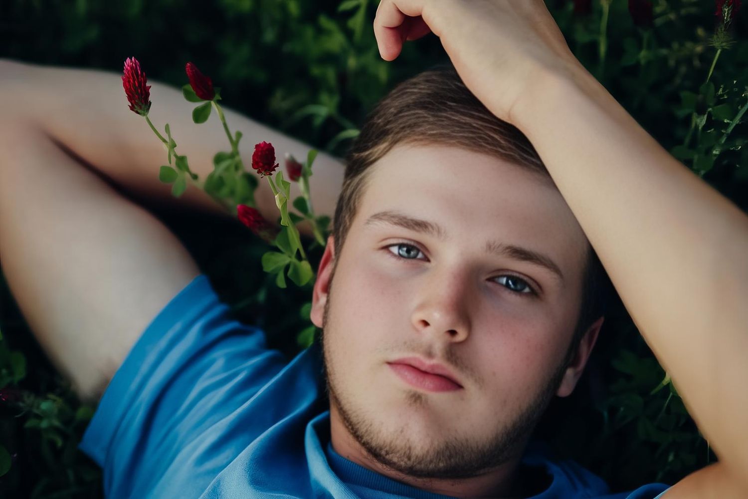 A collage of artistic portrait photos showing someone lying in grass with dramatic lighting and natural outdoor scenery.