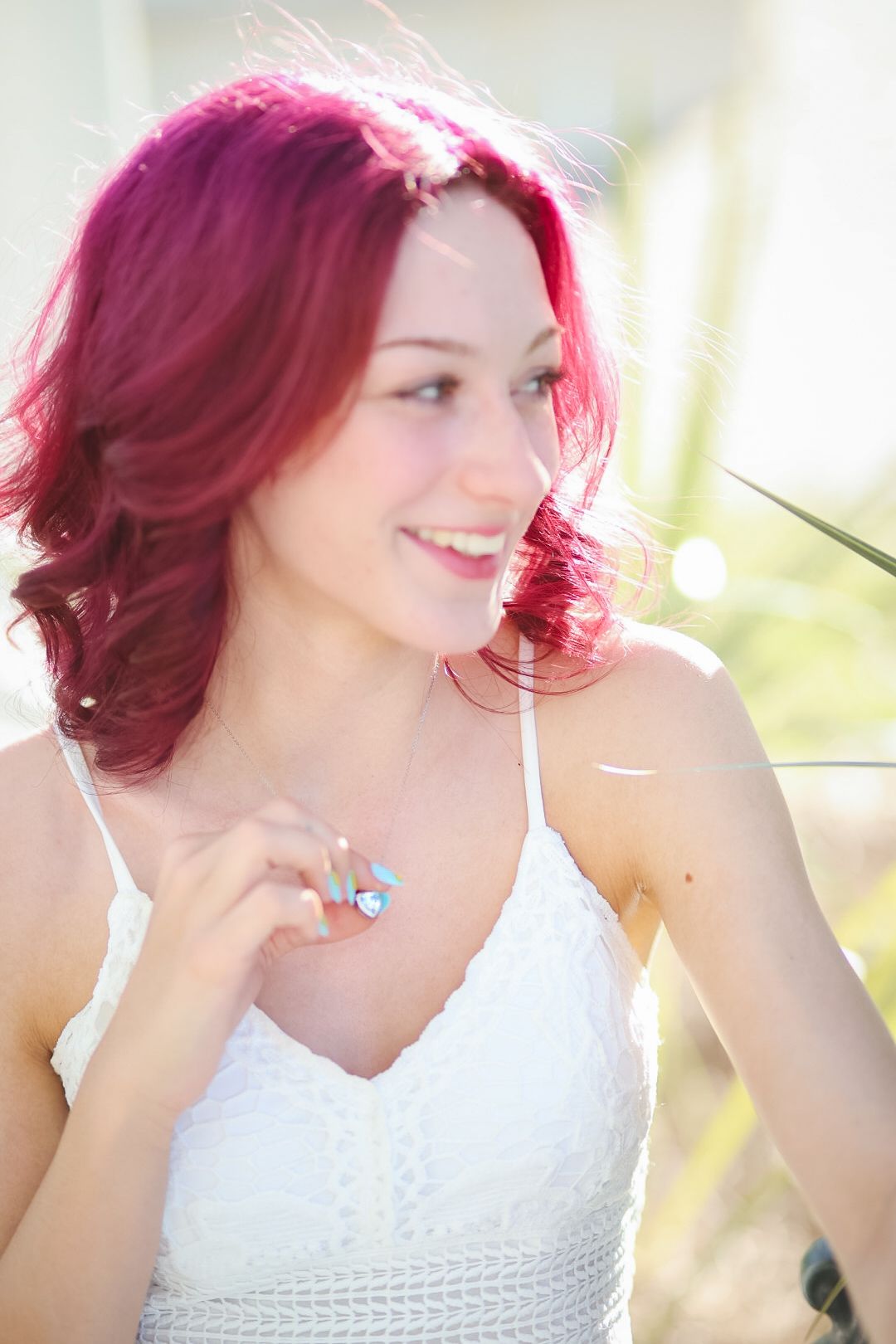 Candid sequence showing someone with bright pink hair wearing a white lace top in sunlit setting.