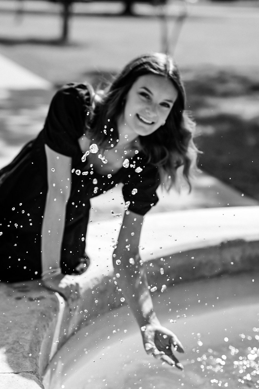 Black and white photo series showing someone splashing and playing in water with joyful energy.