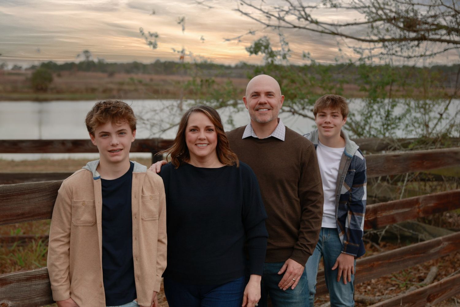 Family gathering outdoors with natural landscape and sunset backdrop.