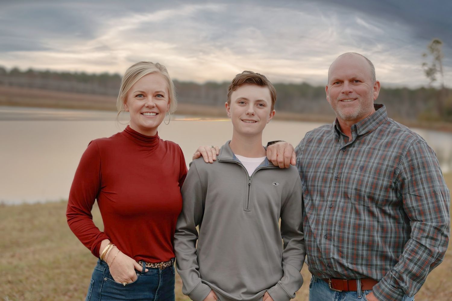 A collection of outdoor family portraits taken in a field at sunset with matching casual attire.