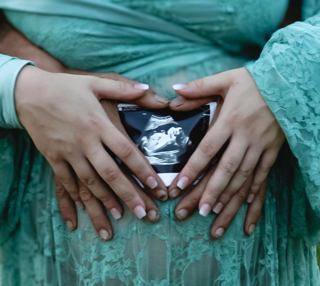 Multiple hands in turquoise dresses reach toward the center in a circular formation creating an artistic composition.