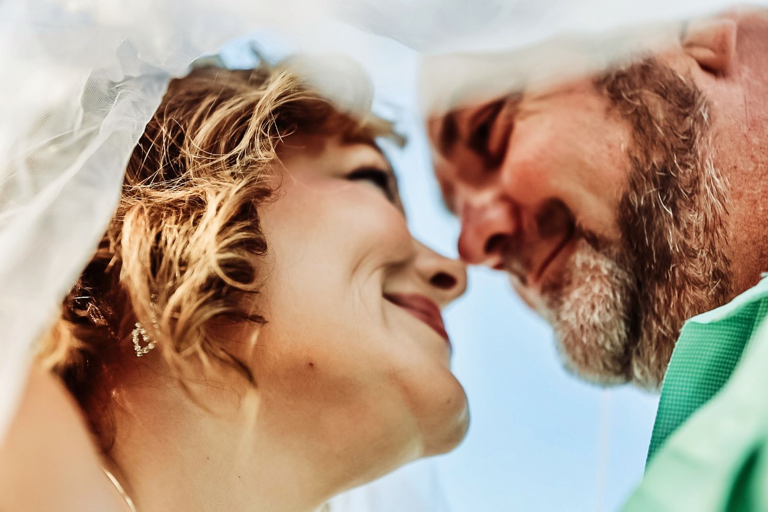 Close-up romantic couple sharing tender moments against bright background.