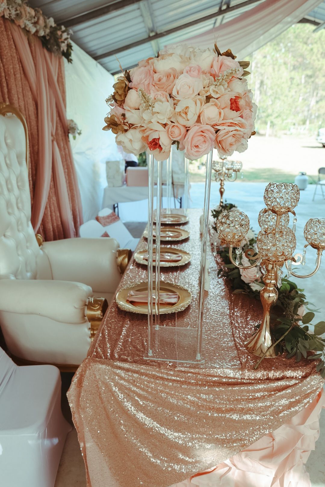 Elegant wedding reception table with rose gold sequin tablecloth, crystal candelabras, gold charger plates, and blush floral centerpiece.