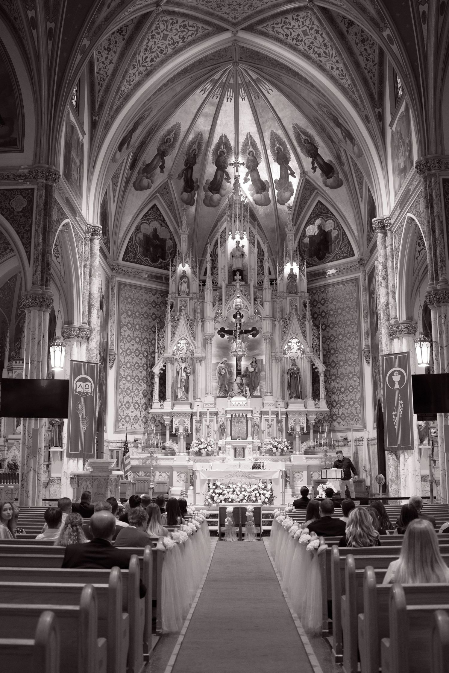 Elegant Gothic church interior filled with wedding guests seated in pews during a formal ceremony.