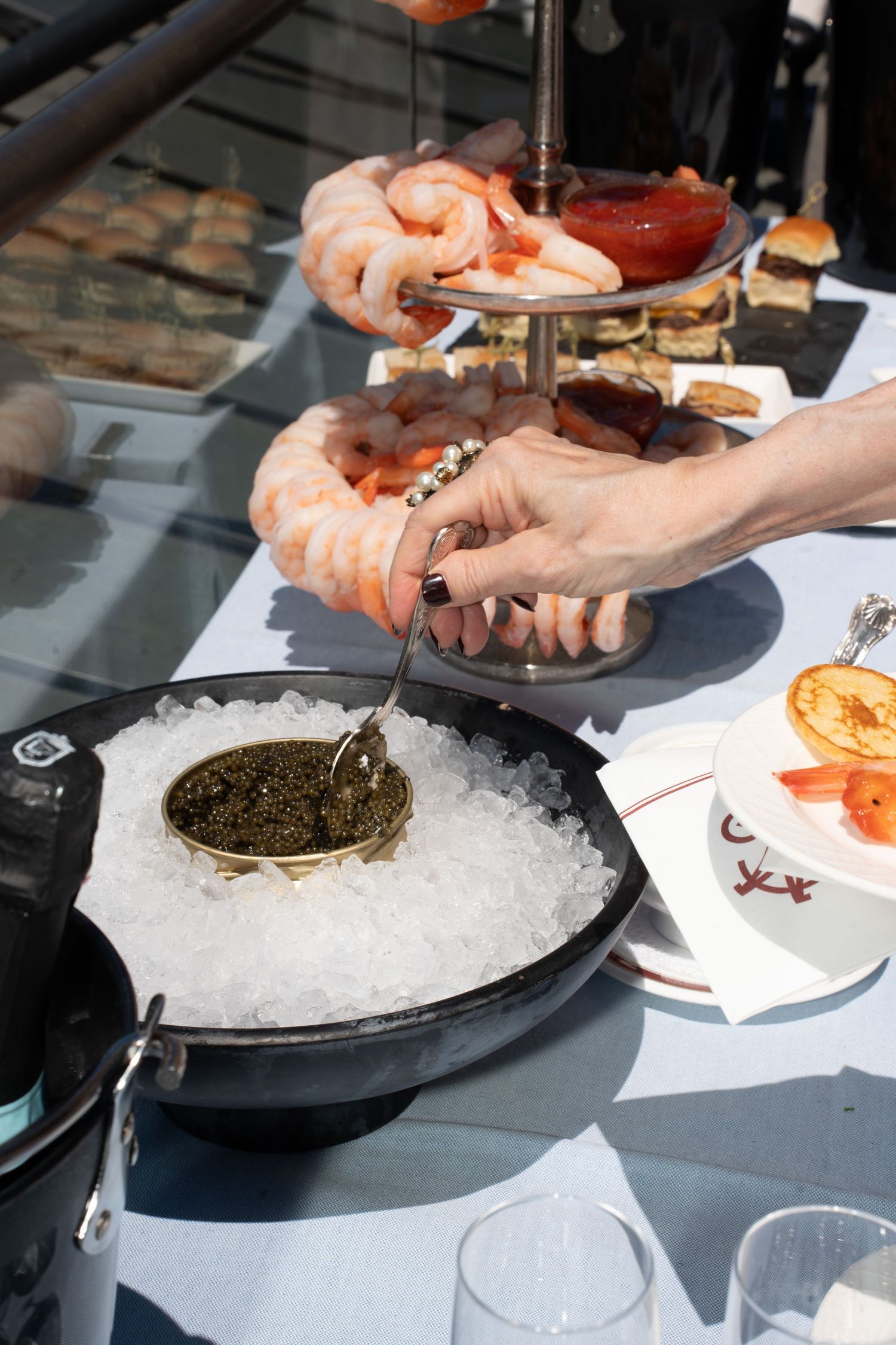 Elegant caviar service on ice with shrimp cocktail tower at upscale New York rooftop event.