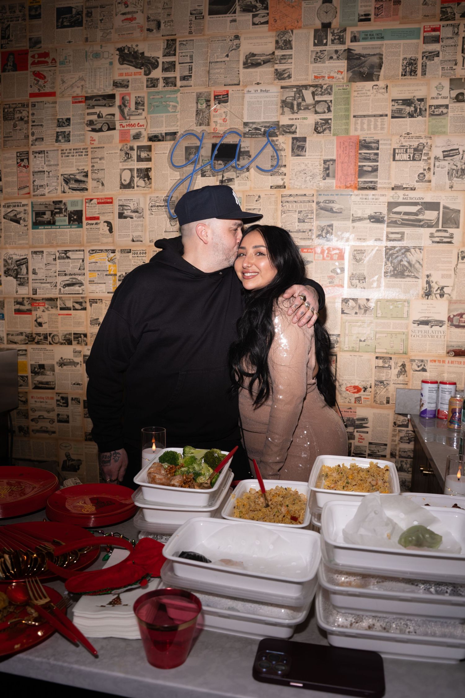 Couple embraces warmly near a food spread at a festive party celebration.