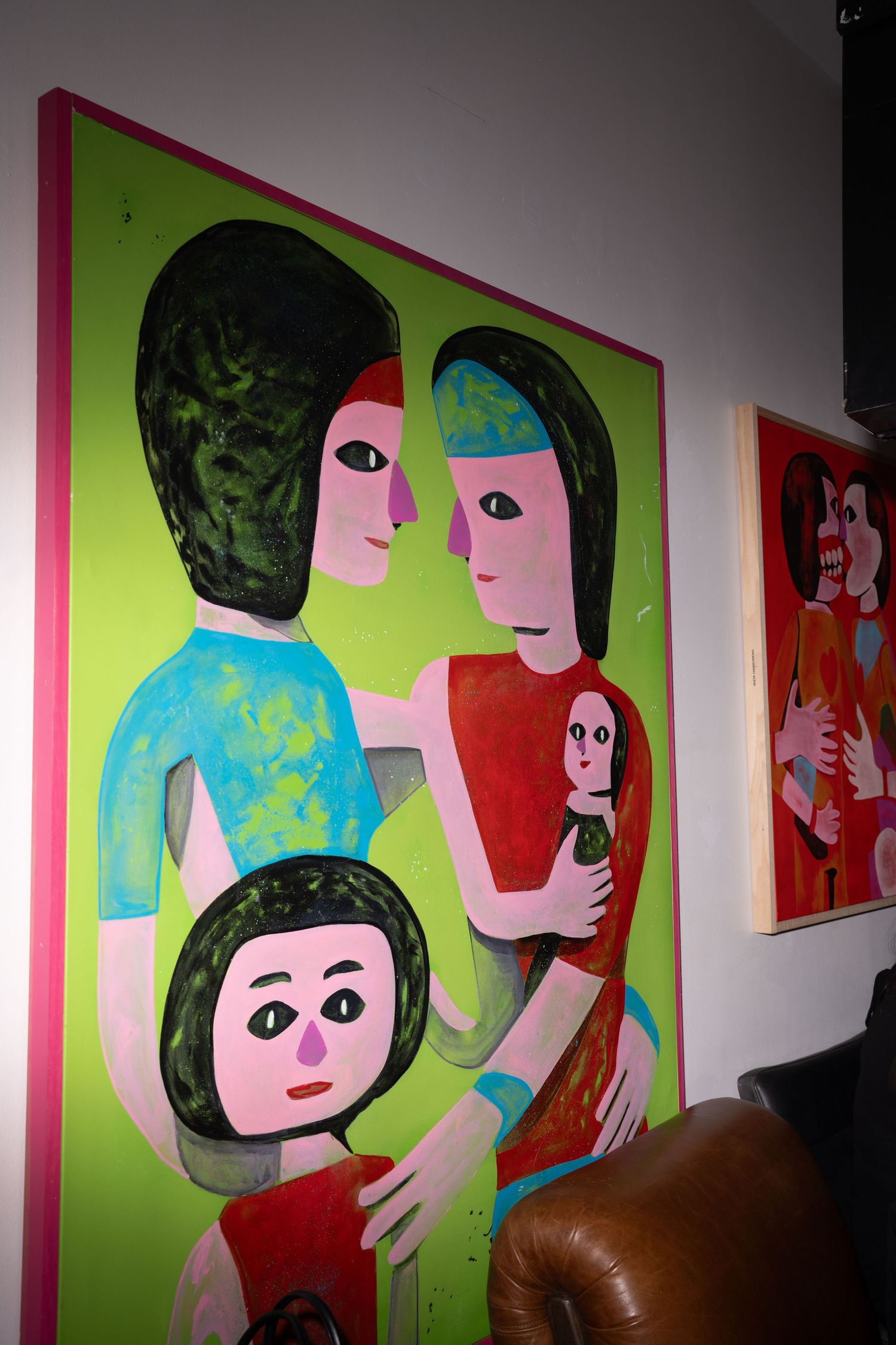 Colorful folk art painting depicting a family group on bright green background.