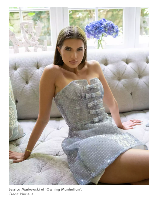 Jessica Markowski of Owning Manhattan in silver sequin strapless mini dress on tufted sofa.
