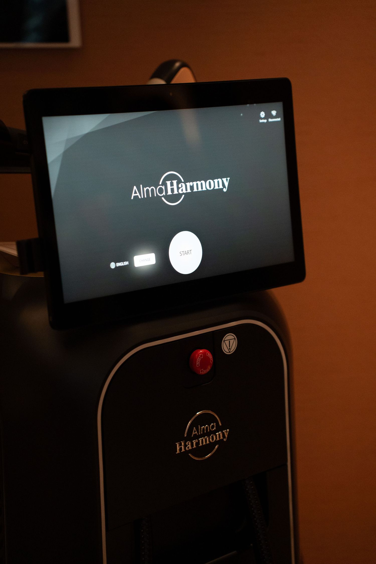 Alma Harmony laser aesthetic treatment device with touchscreen interface displayed in a medical spa.