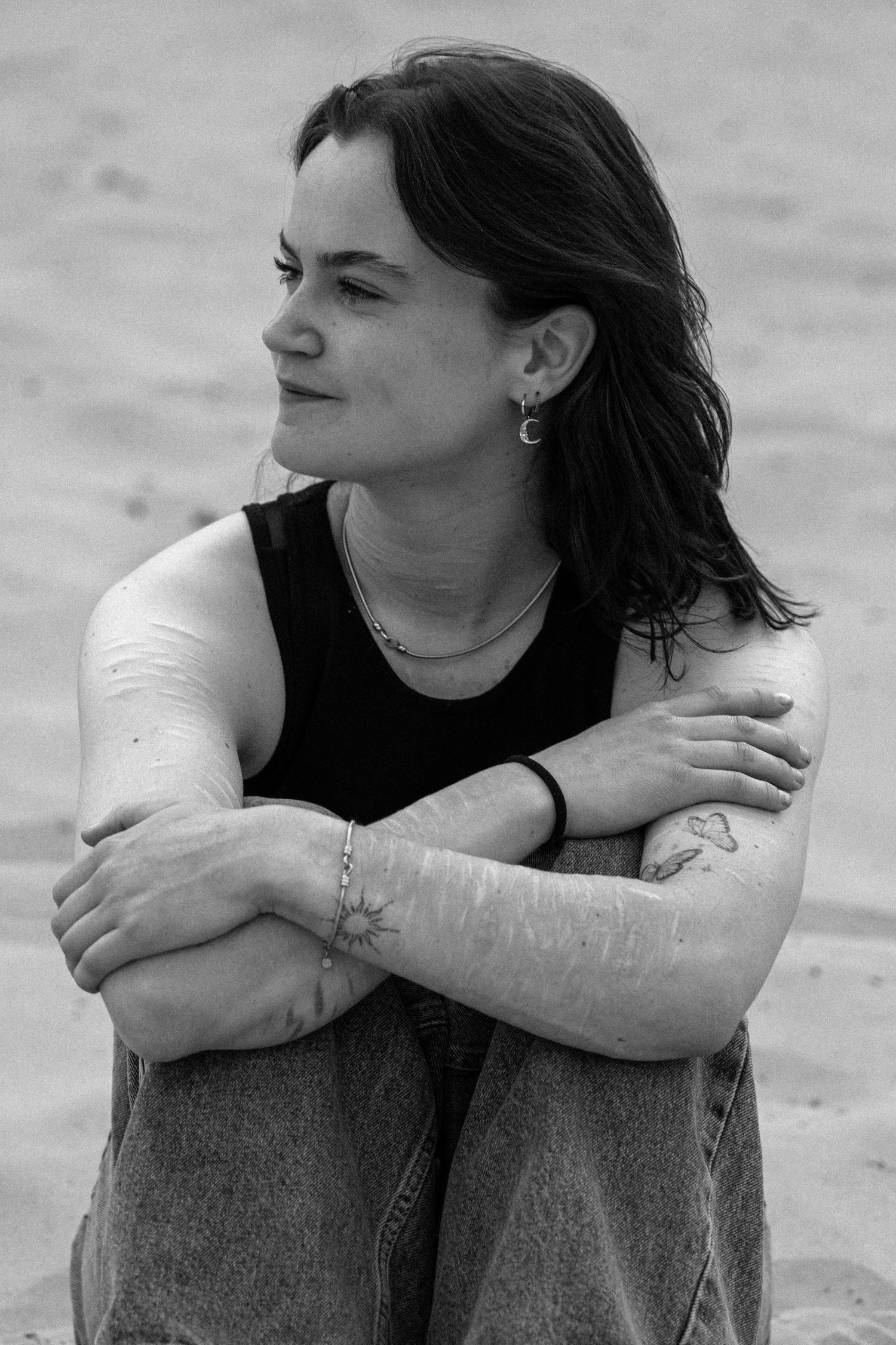 Portret met tatoeages en sieraden in zwart-wit.