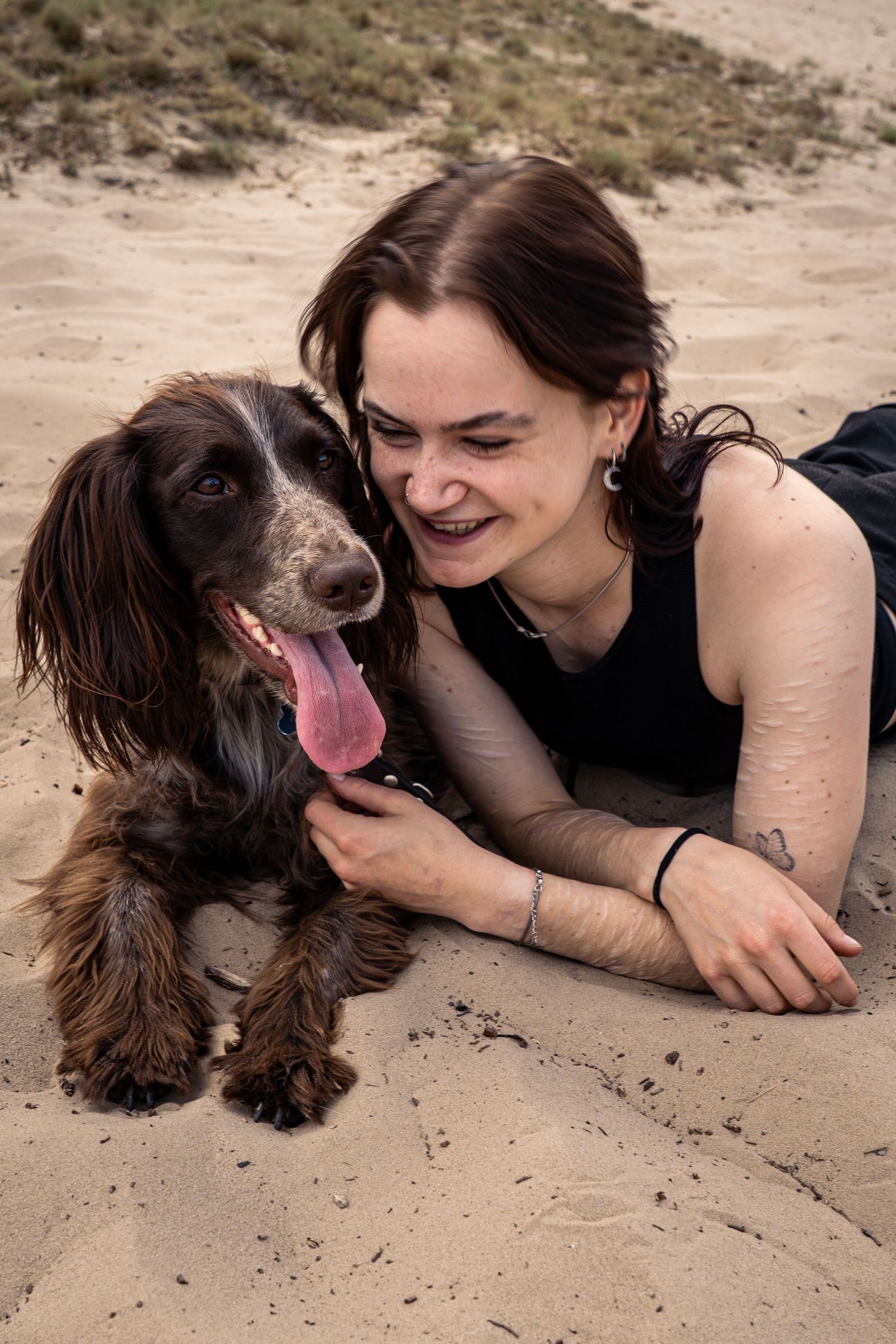 Bruine hond en eigenaar genieten in de duinen.