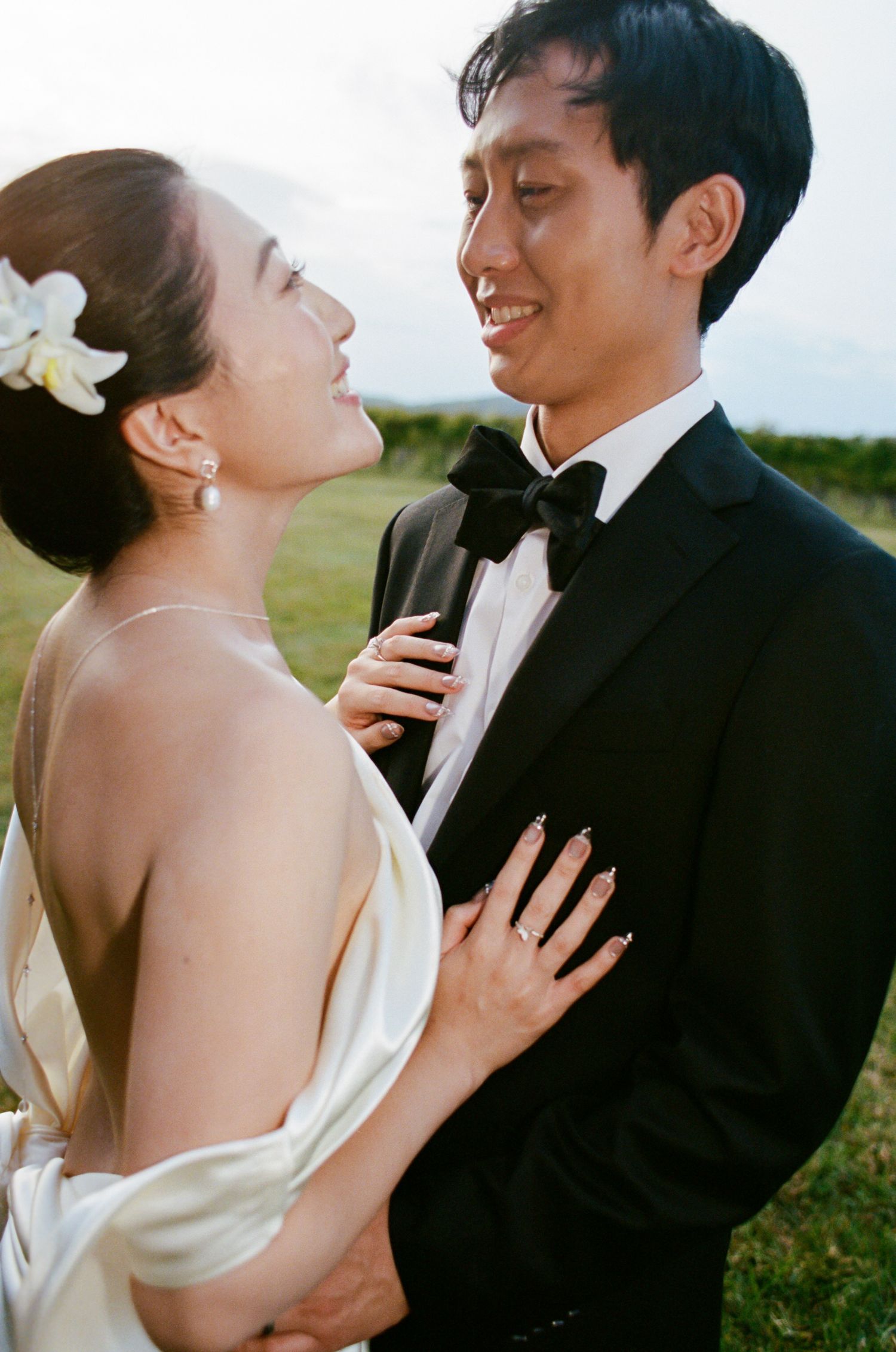 A romantic wedding photo series showing intimate moments between a couple in formal attire against a natural backdrop.