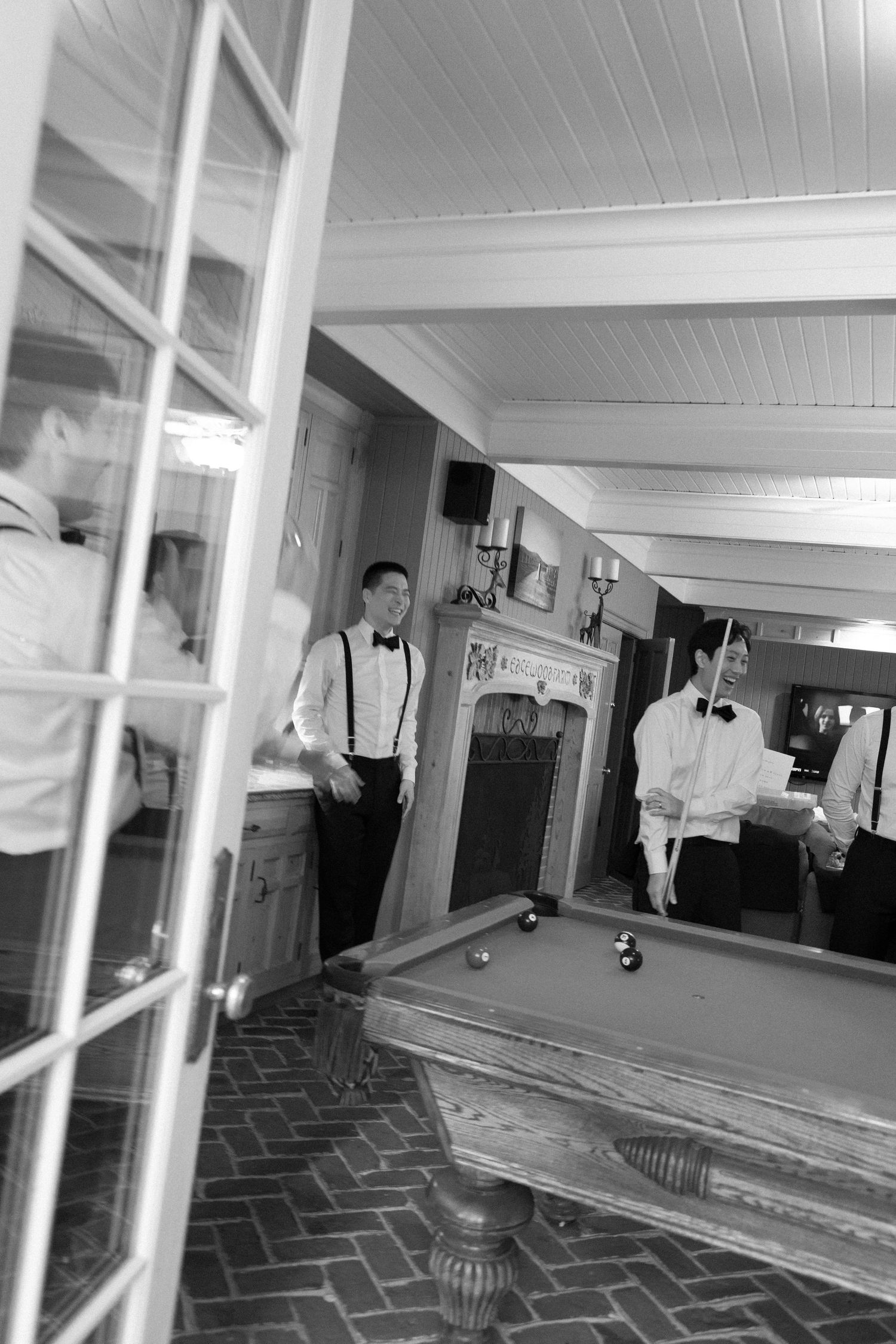 A black and white security camera footage shows figures in white protective suits walking through a dimly lit corridor.