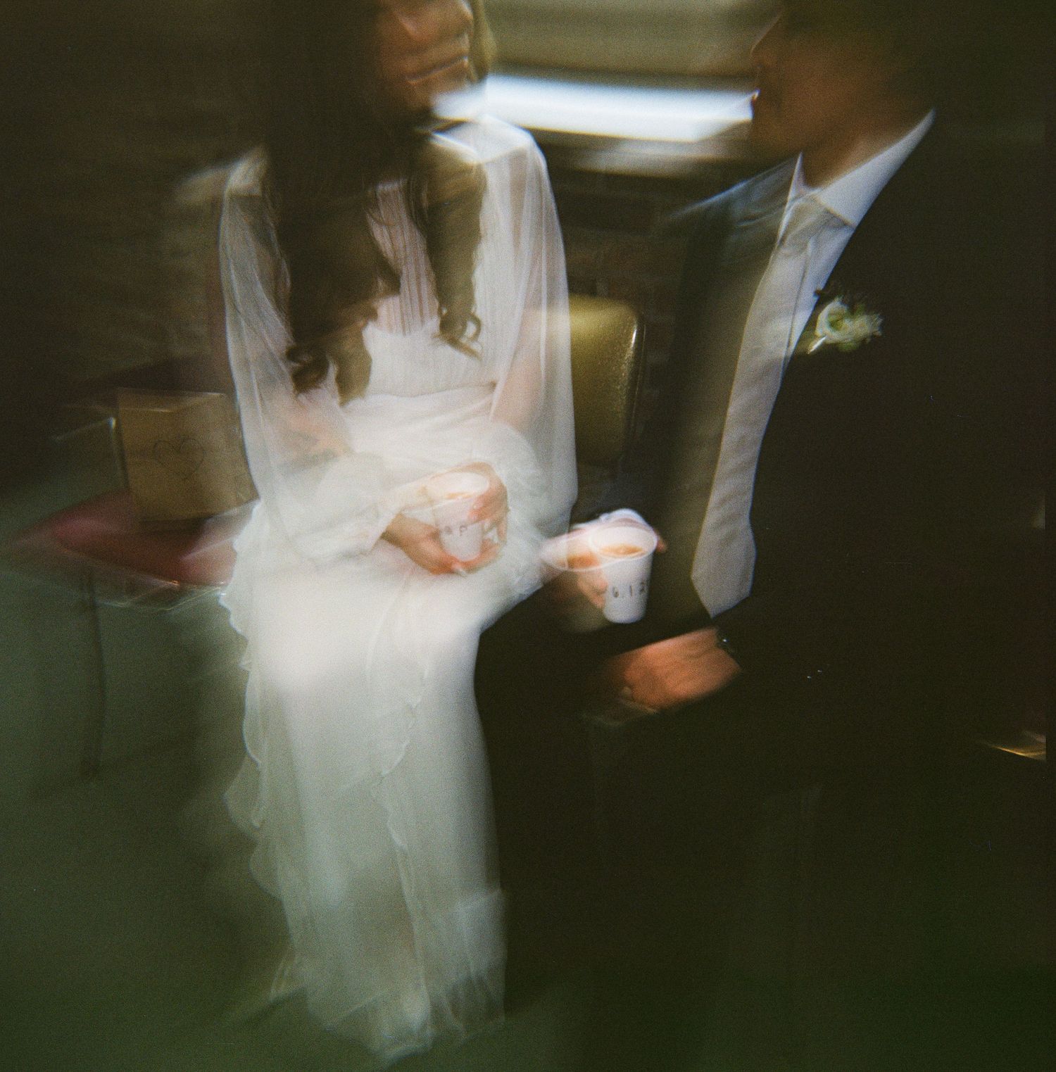 Motion-blurred wedding dance photos show ethereal swirls of white dress and dark suit in dim lighting.