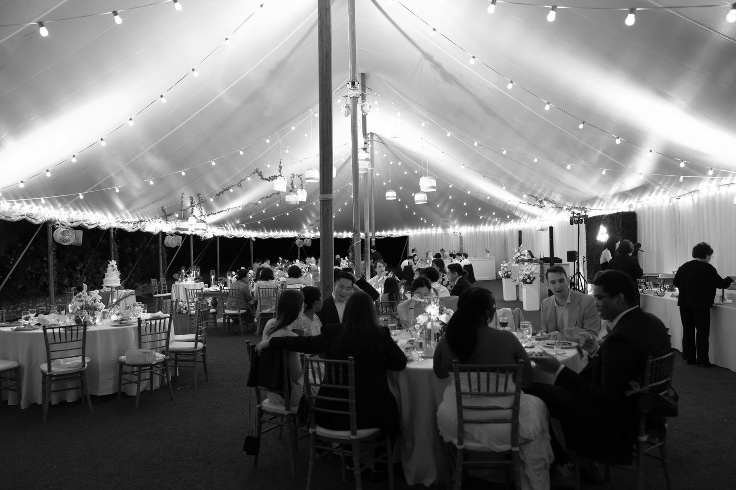 Black and white photos show a large event tent with string lights and tables set up for a formal celebration.