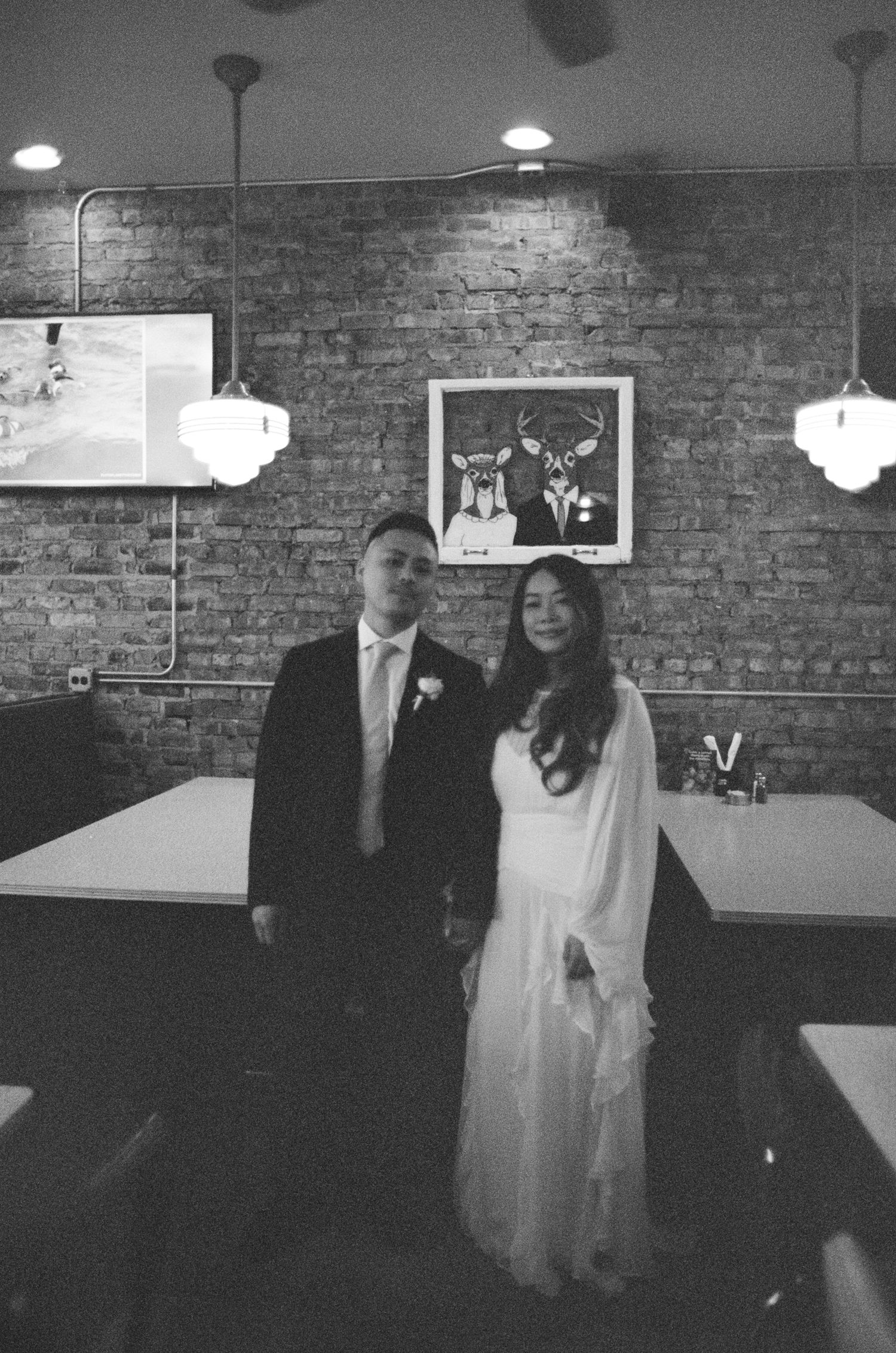 Black and white photo sequence showing a couple dancing together at a reception venue with exposed brick walls.
