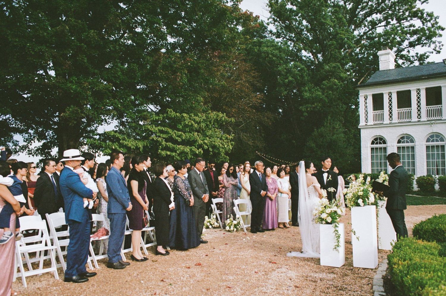 A series of outdoor wedding ceremony photos showing guests seated on white chairs in a garden setting.