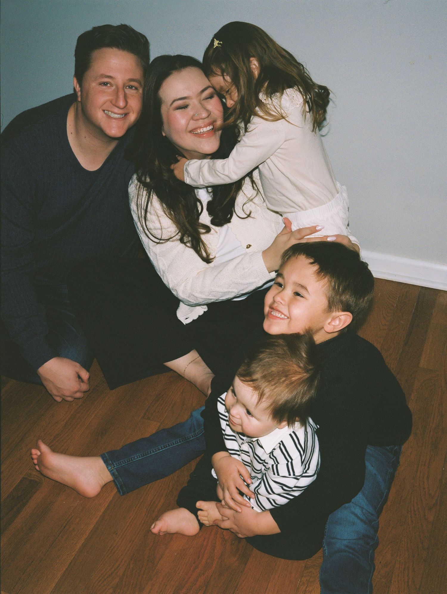 A series of candid photos showing people embracing and laughing together on a hardwood floor.