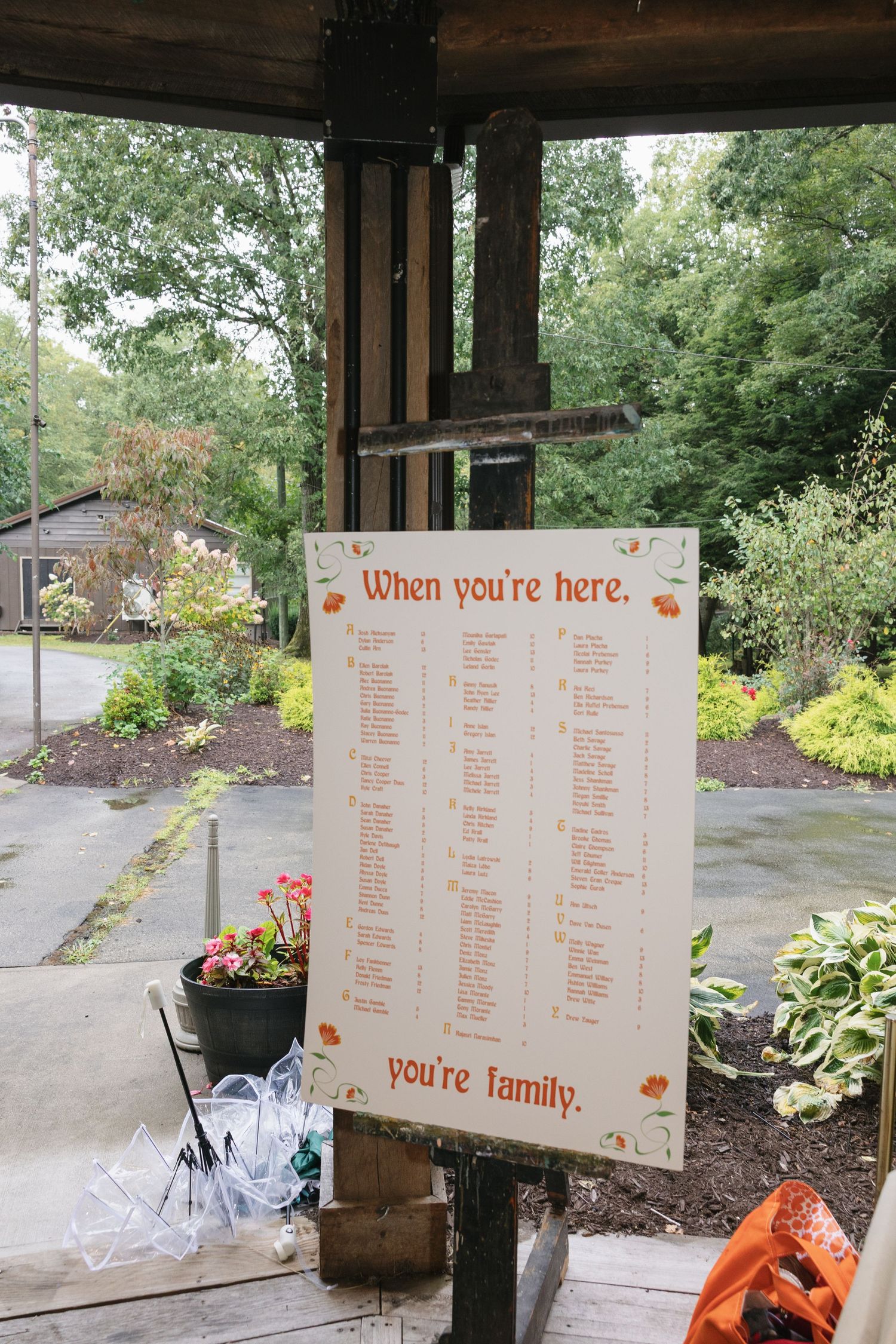 Wedding seating chart display boards with orange fall leaf accents arranged at an outdoor venue.