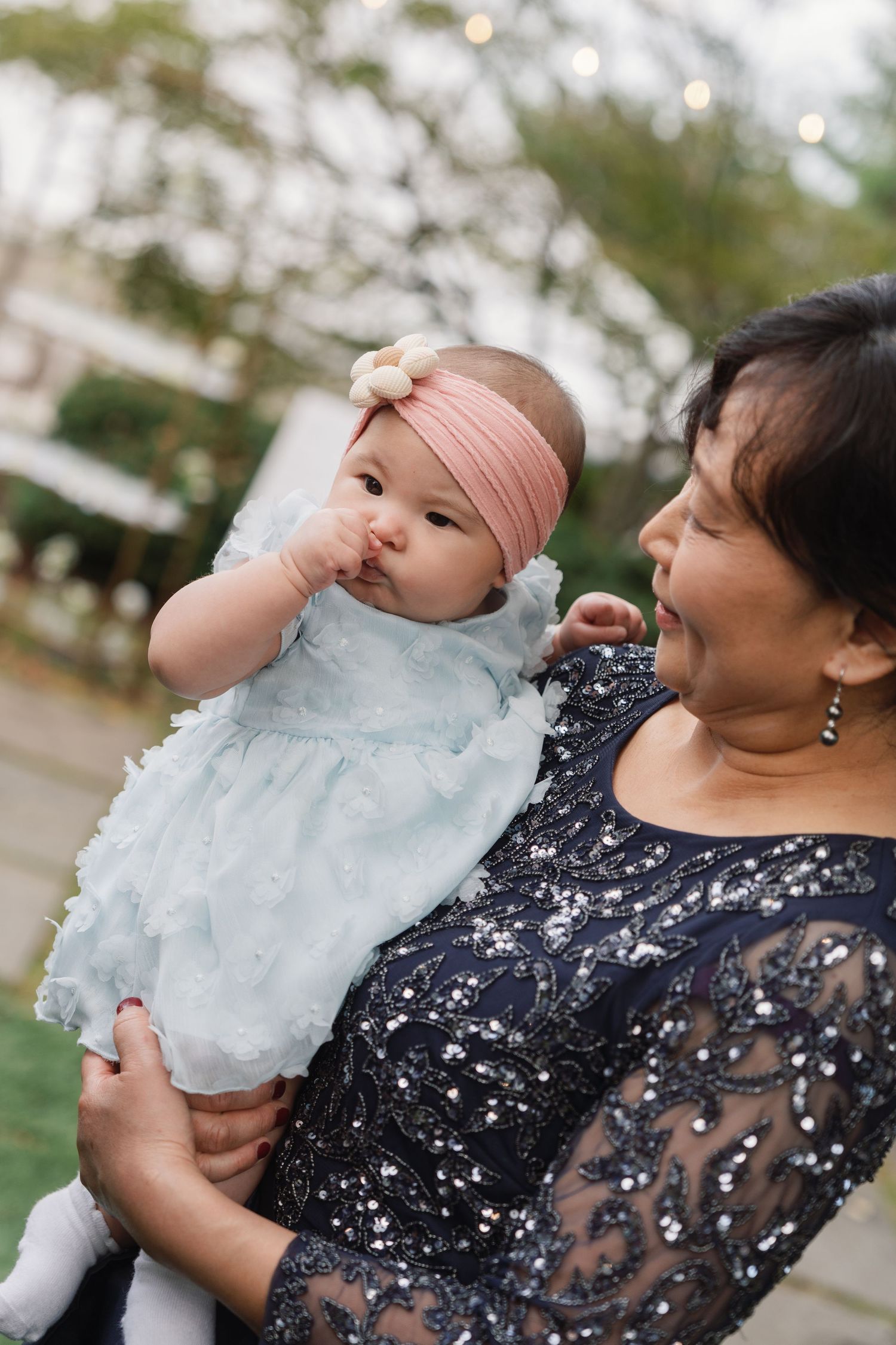 A person in a floral dress enjoying cotton candy outdoors in a series of sequential photos.