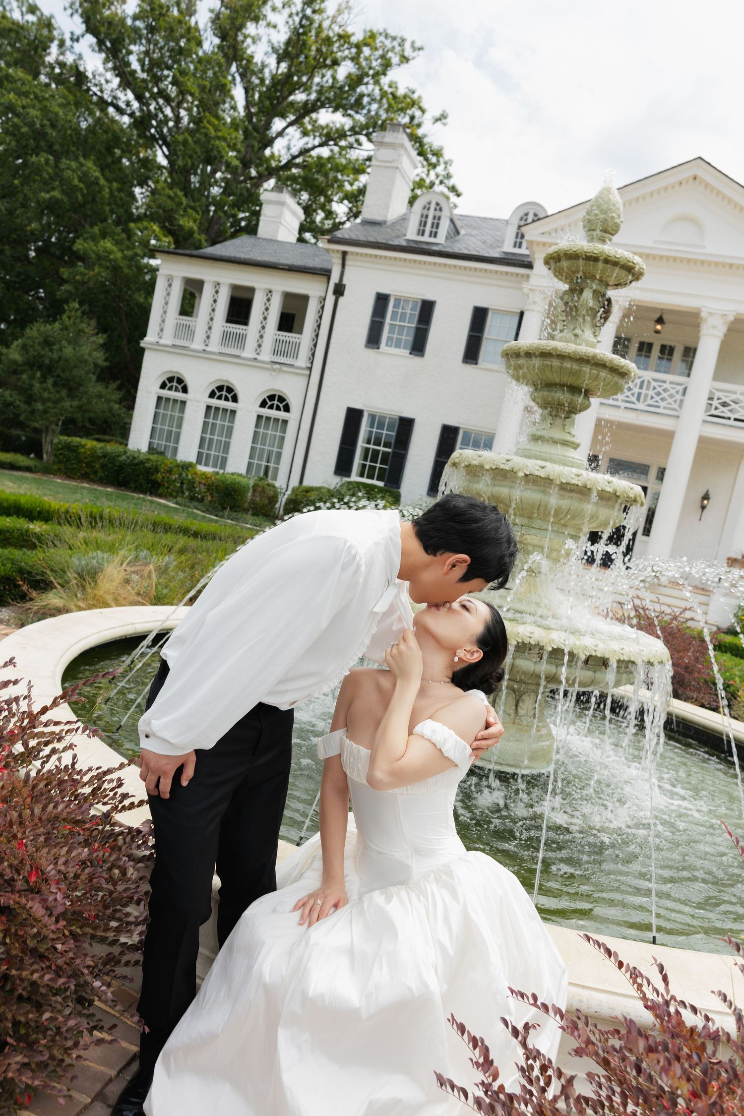Romantic wedding couple poses in a series of elegant shots by a grand white fountain at an upscale venue.