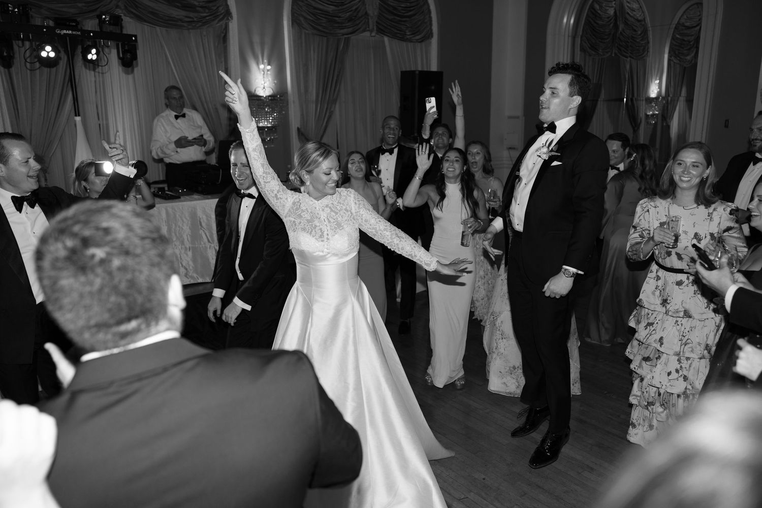 Black and white photo of bride and groom sharing first dance at elegant wedding reception.