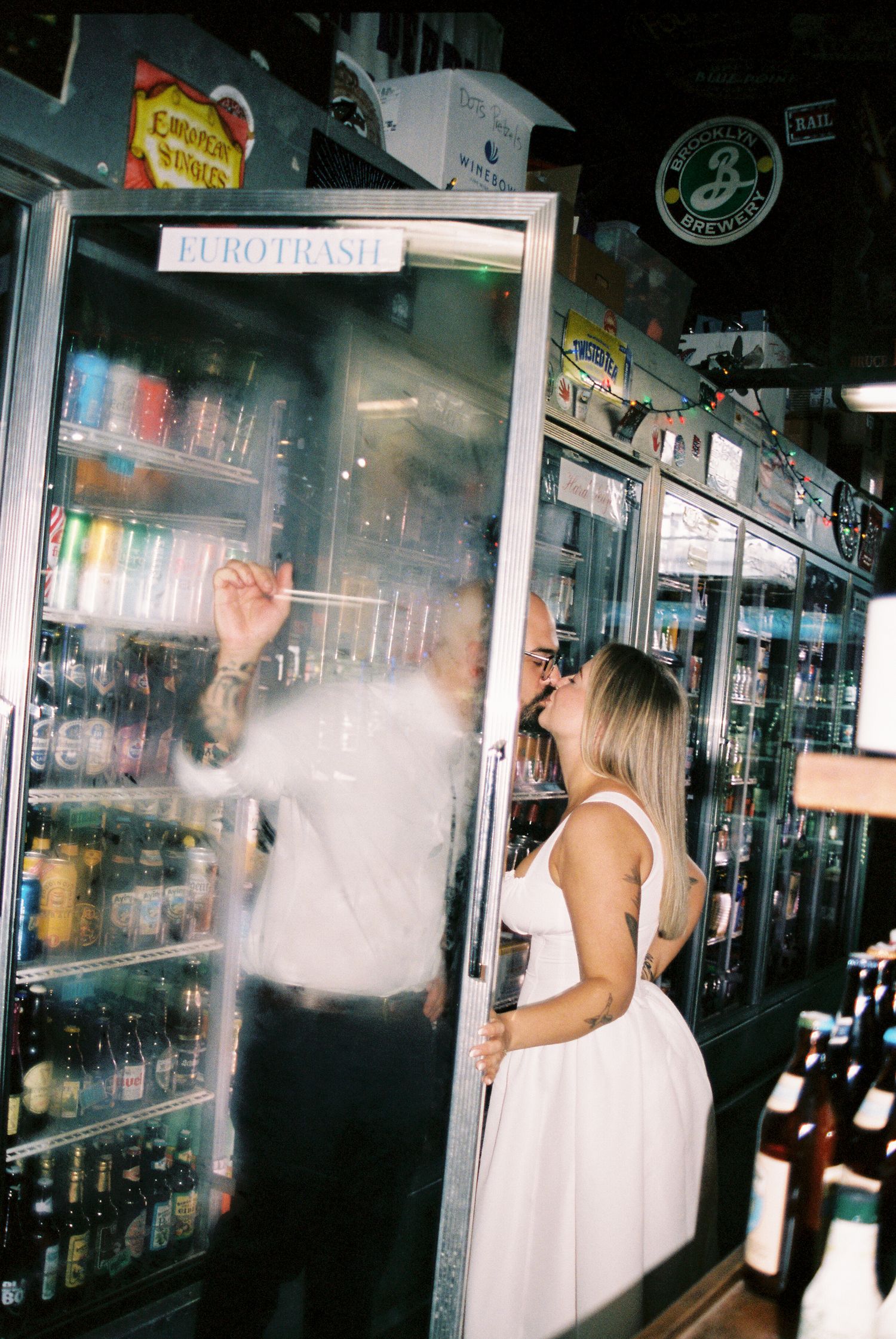 A series of four film photos showing someone in a white dress moving through a dimly lit bar or nightclub interior.
