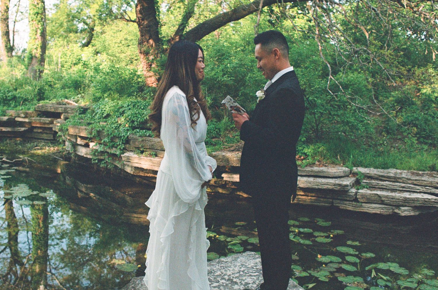 A couple shares a romantic moment in a lush garden setting during their wedding photoshoot.